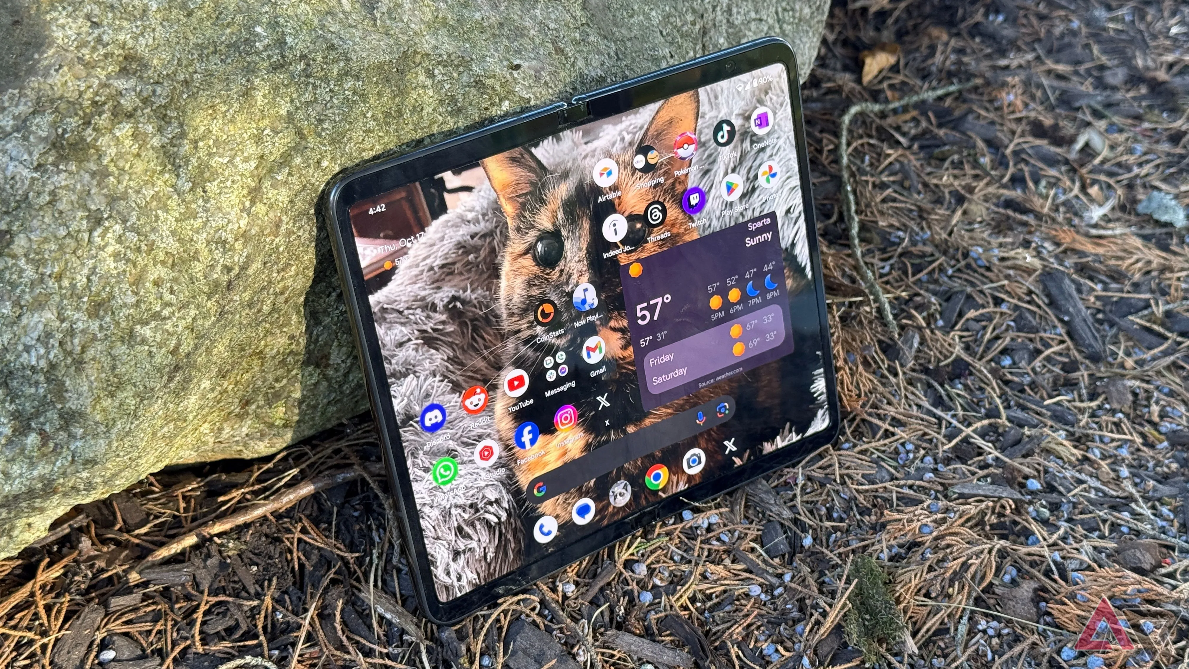 Điện thoại Google Pixel Fold ở trạng thái gập, đặt nghiêng ngoài trời.