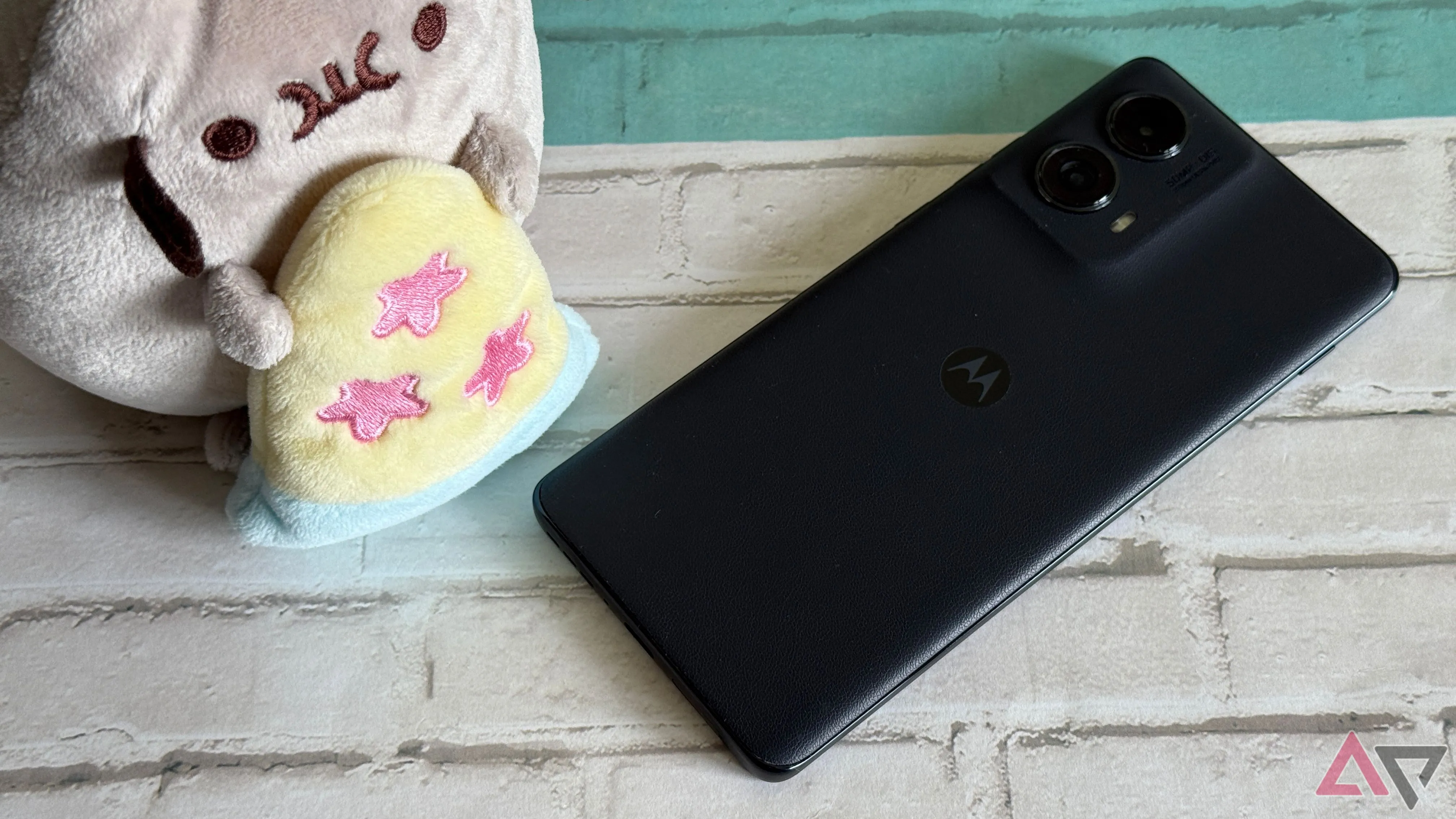 Điện thoại tầm trung Motorola Edge 2025 đặt cạnh mô hình Pusheen ăn pizza