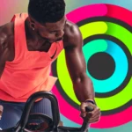 Huấn luyện viên Apple Fitness+ đang tập luyện với vòng Hoạt động đã đóng trên nền màu sắc