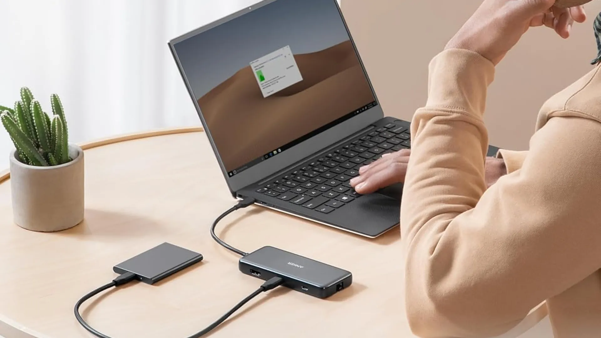 Hub USB-C Anker 555 8-in-1 trên bàn làm việc kết nối với laptop