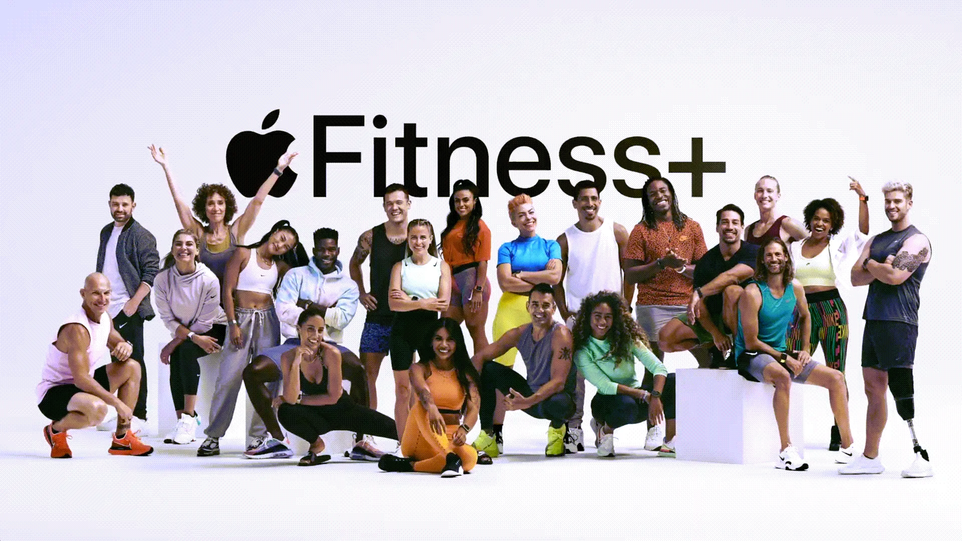 Nhóm lớn các huấn luyện viên cá nhân đứng trước logo Fitness+
