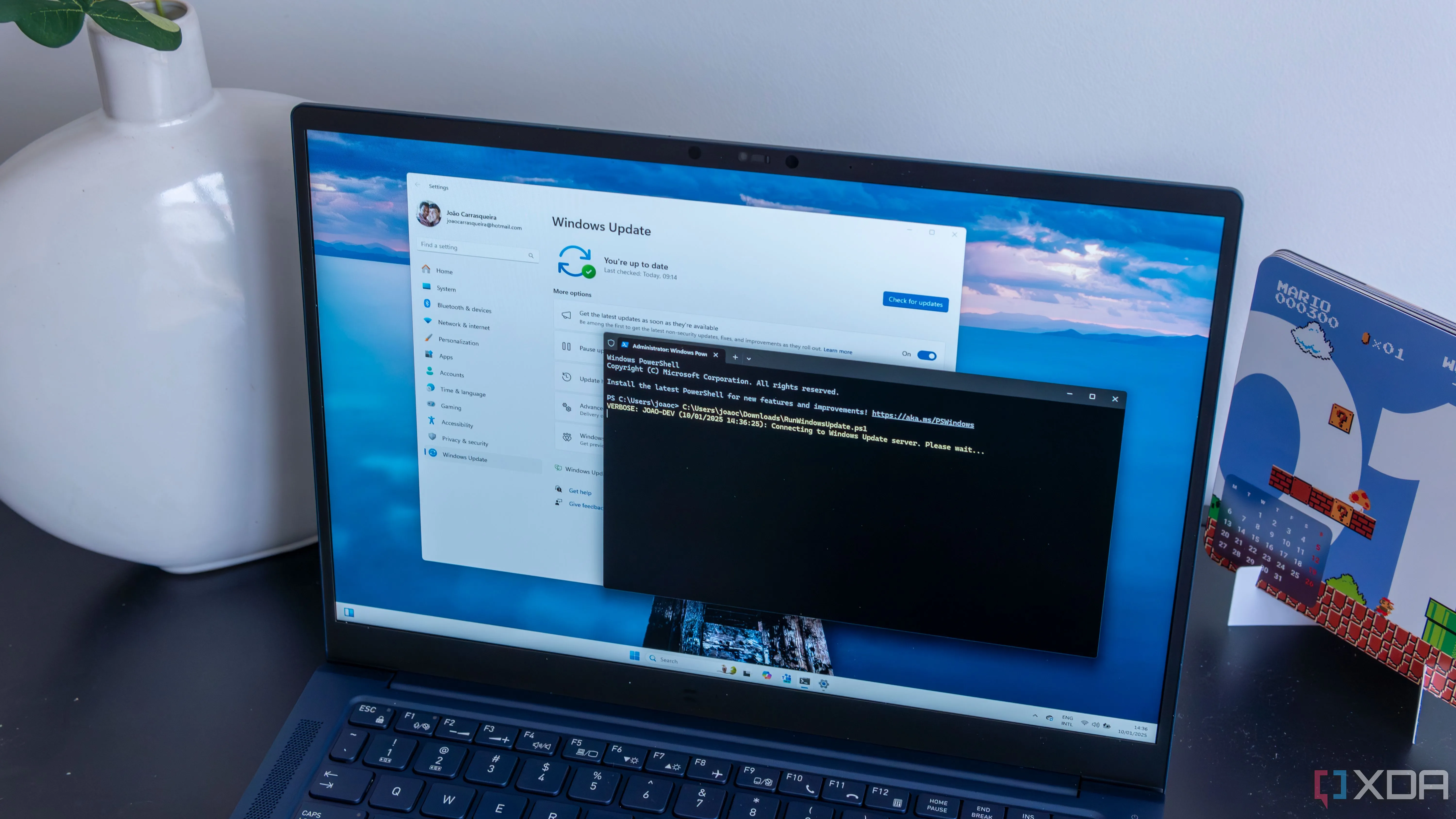 Màn hình laptop Windows 11 hiển thị cửa sổ PowerShell đang chạy script tự động cập nhật và khởi động lại