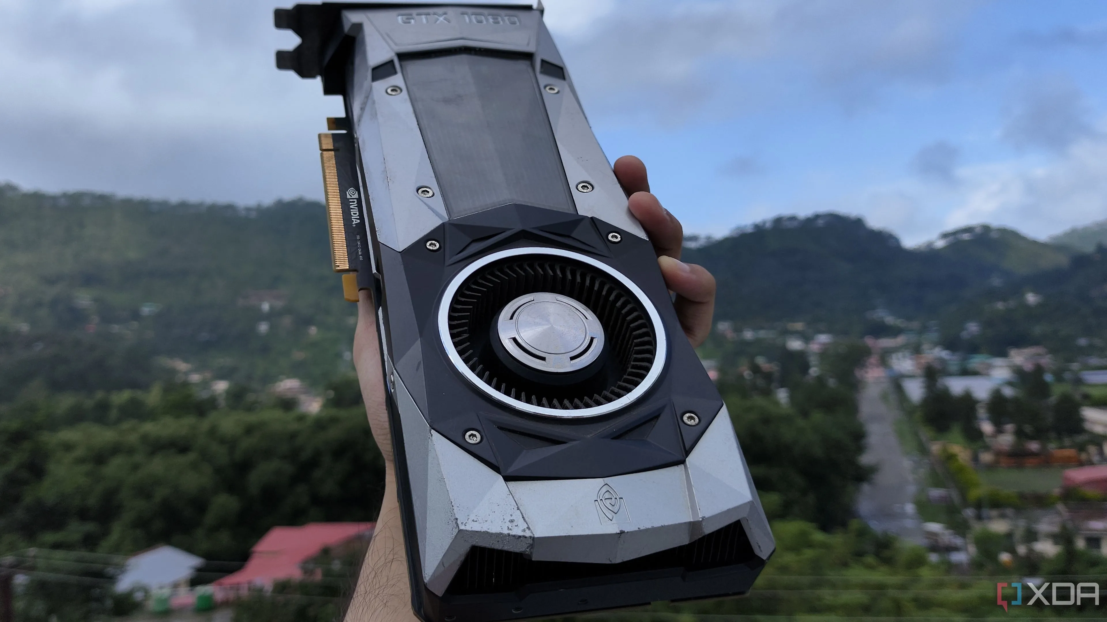 Một người cầm card đồ họa NVIDIA GeForce GTX 1080 Founders Edition biểu tượng cho hiệu năng đã qua