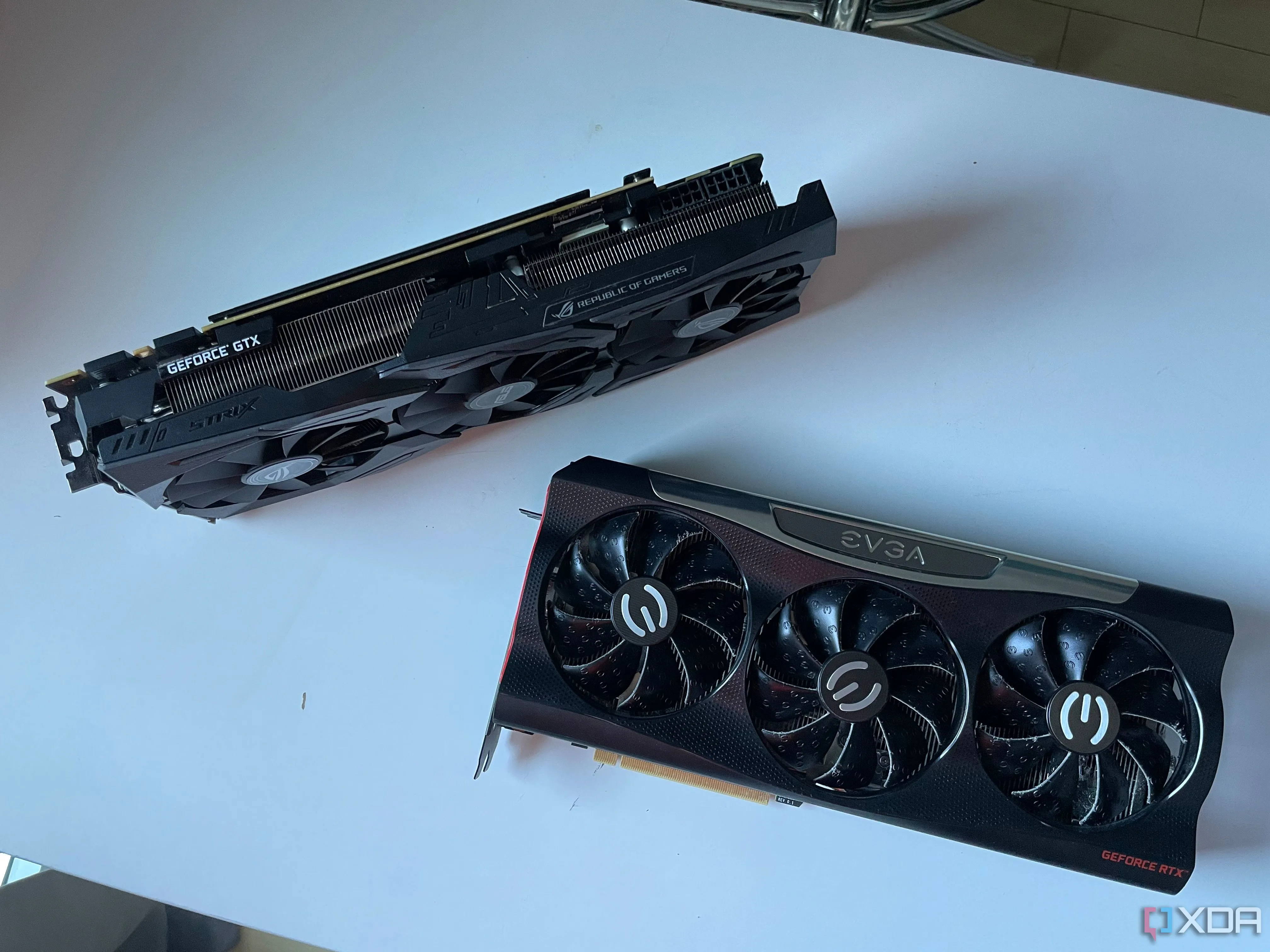 Ảnh chụp card đồ họa ASUS STRIX 1080 Ti và EVGA RTX 3080 đặt trên bàn