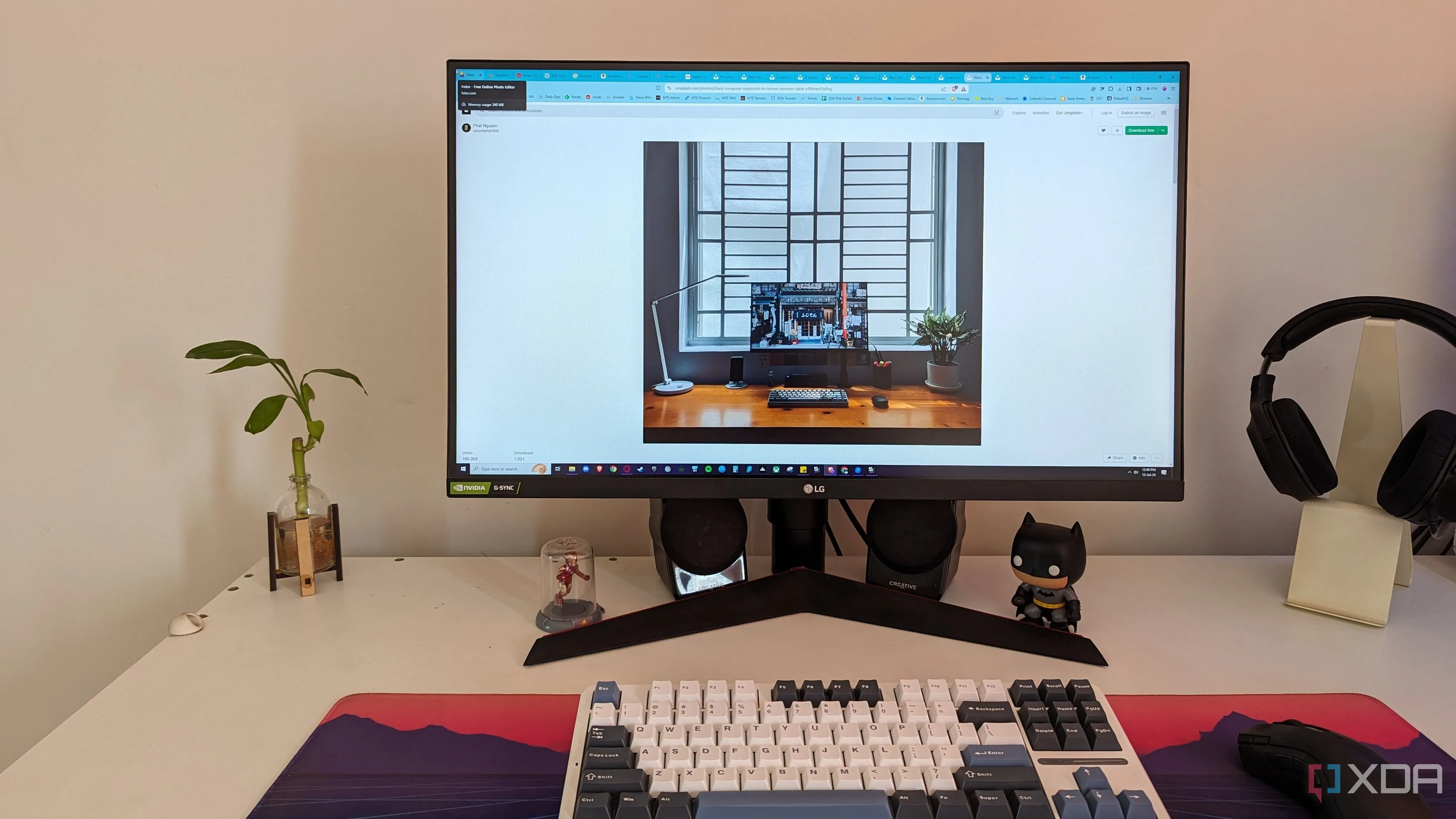 Bàn làm việc với máy tính PC, màn hình và cây xanh, tạo không gian thoải mái khi làm việc