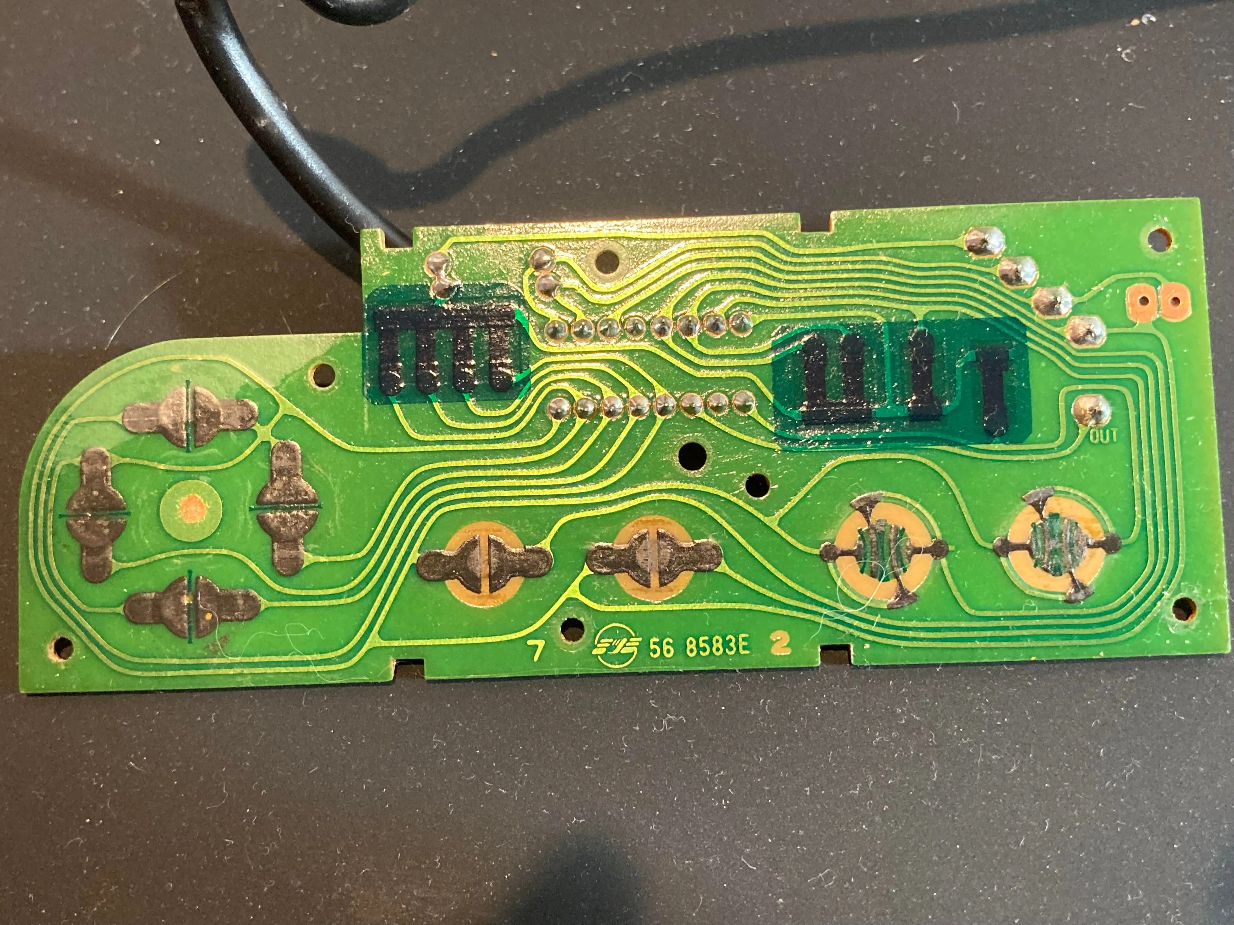 Bảng mạch PCB mặt trước bên trong tay cầm NES với các tiếp điểm nút