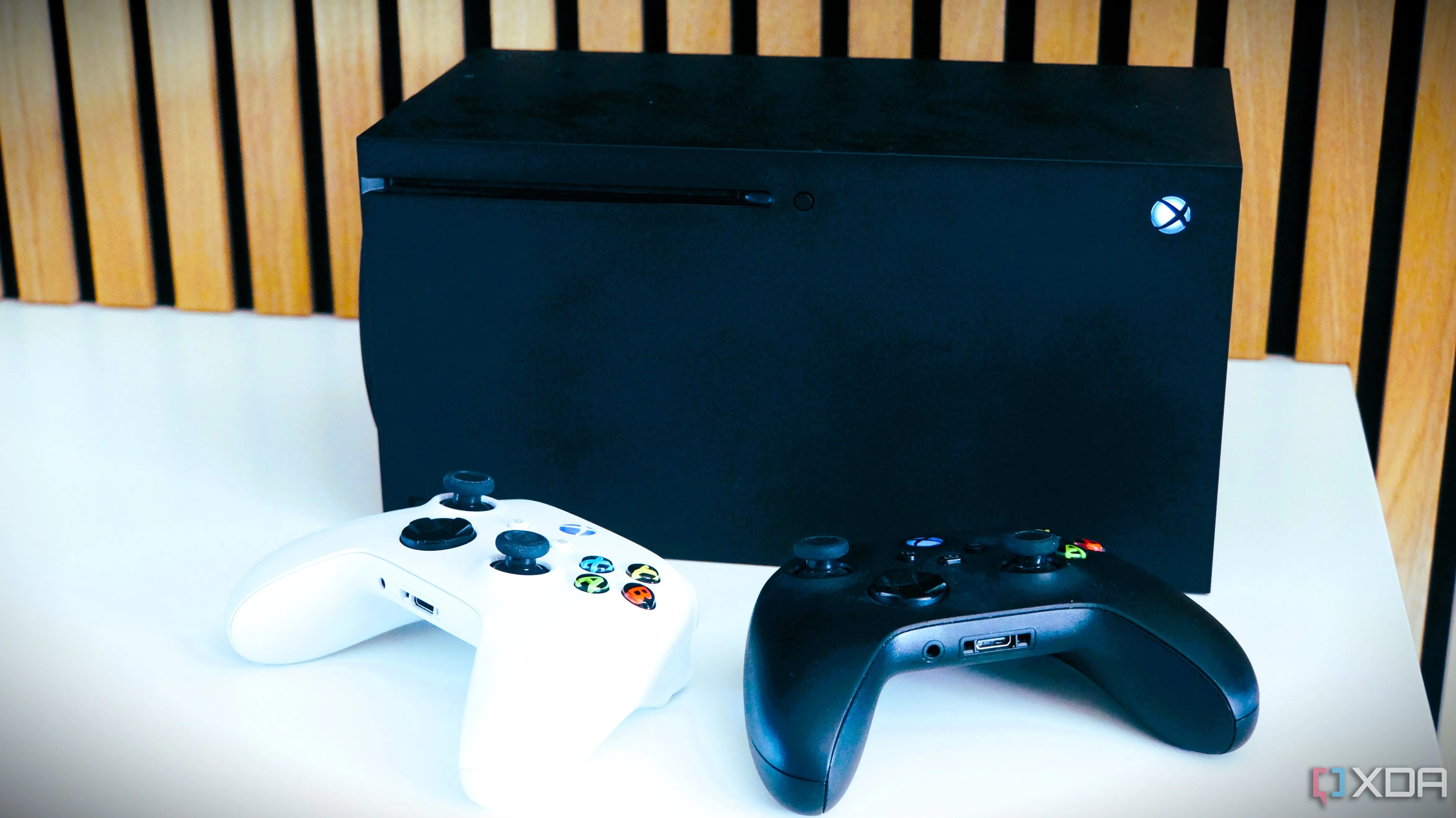 Bộ đôi tay cầm chơi game Xbox và máy console Xbox Series X, minh họa cho việc tăng giá phần cứng và game của Microsoft