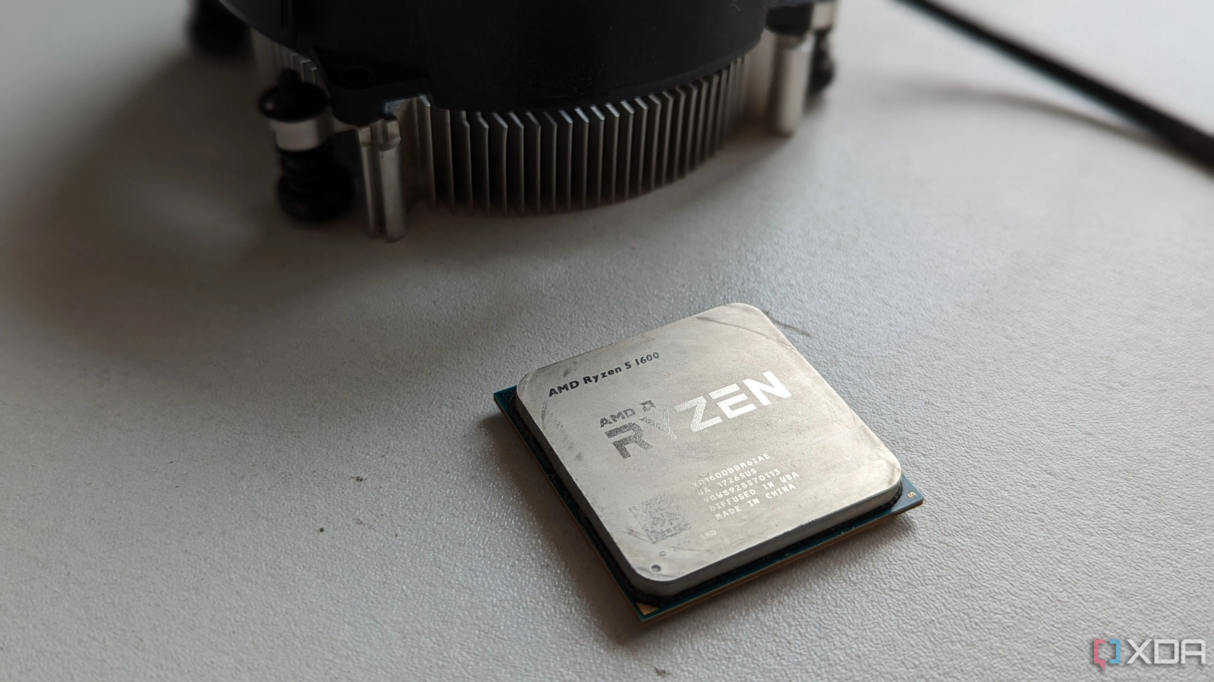 Bộ vi xử lý Ryzen 5 1600 và tản nhiệt đi kèm trên bề mặt trắng