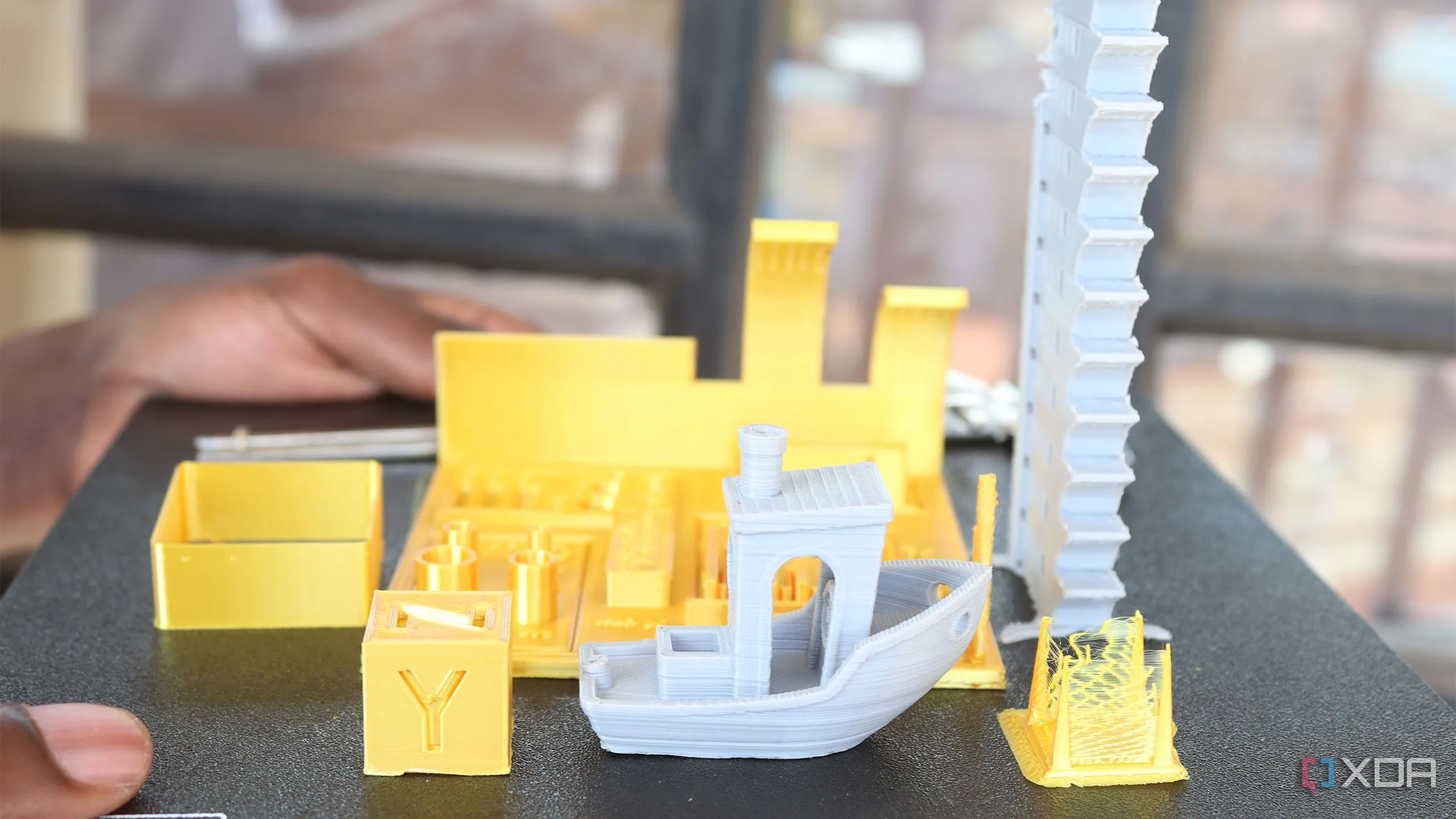 Các mẫu in 3D thử nghiệm đặt trên bàn máy in, thể hiện sự đa dạng của dự án