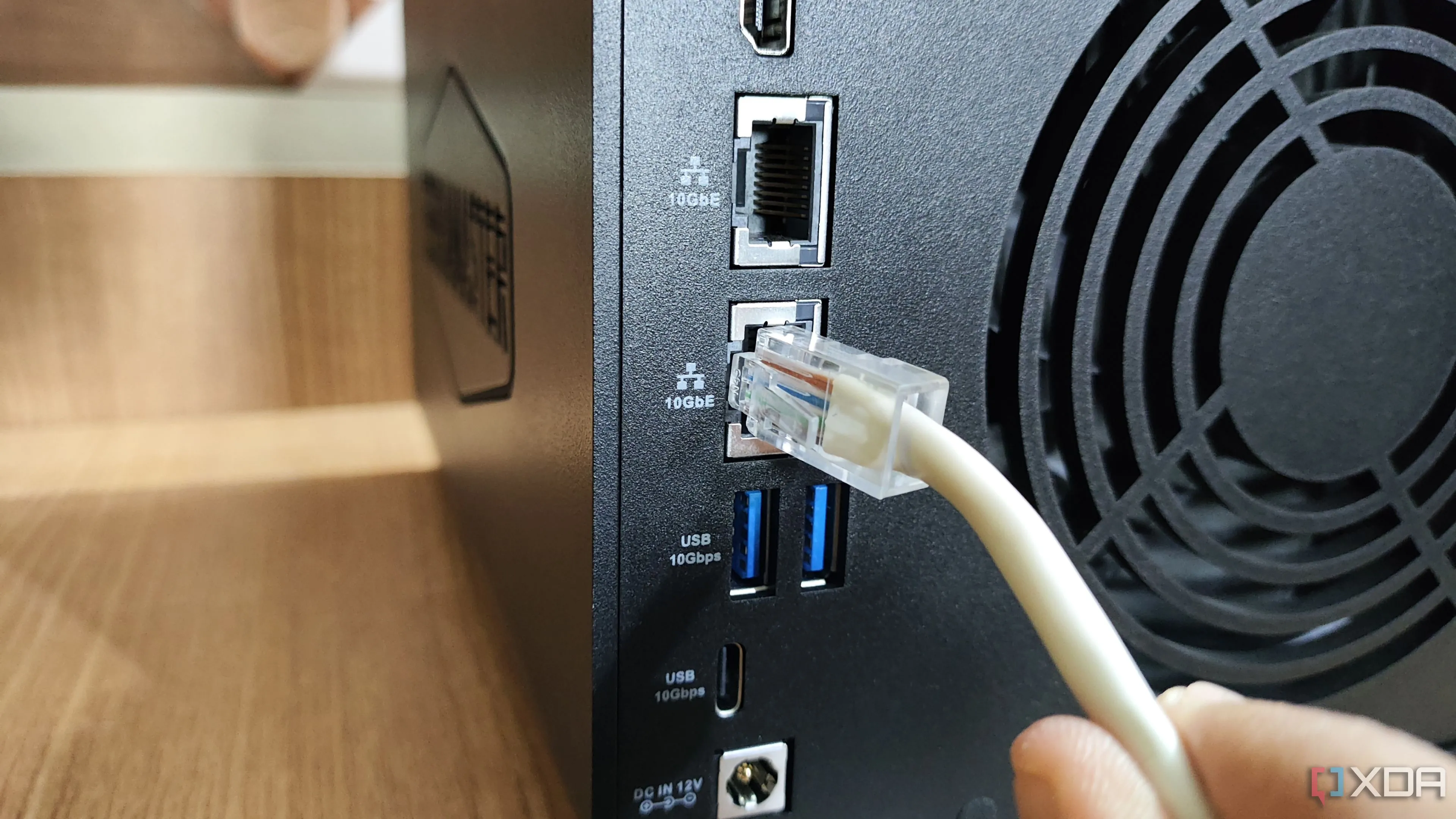 Cắm cáp Ethernet vào cổng LAN 10GbE trên thiết bị NAS TerraMaster F4-424 Max, thể hiện kết nối mạng có dây đáng tin cậy và tốc độ cao.