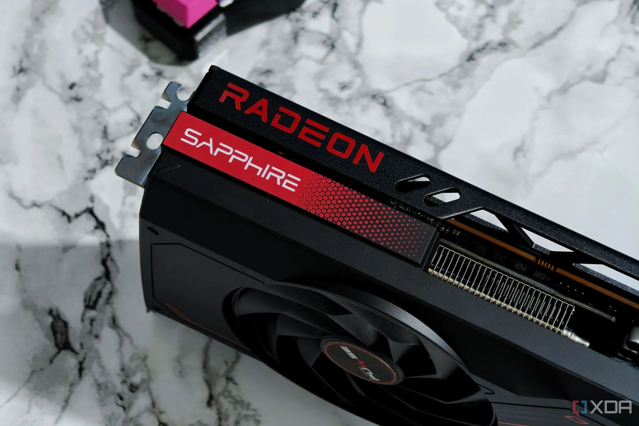 Card đồ họa AMD Radeon RX 7700 XT đặt trên bàn đá, tượng trưng cho phần cứng GPU của AMD.
