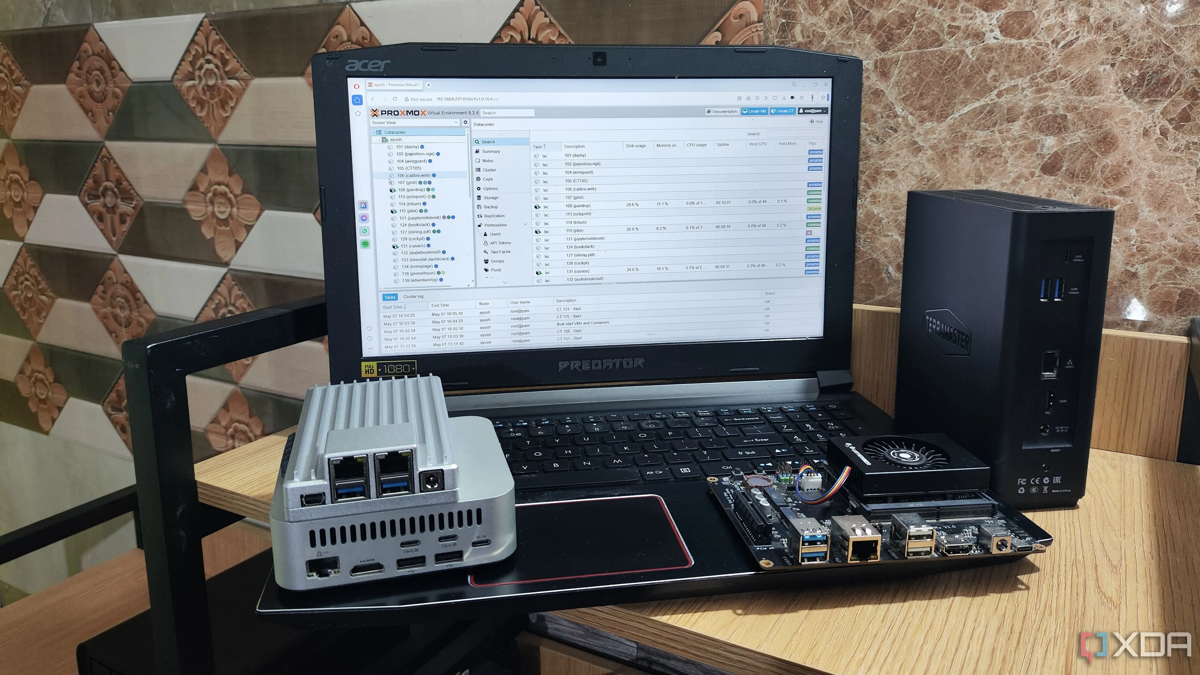 Giao diện quản lý web Proxmox được truy cập từ một chiếc laptop, thể hiện việc quản lý dễ dàng các dịch vụ ảo hóa trên home lab