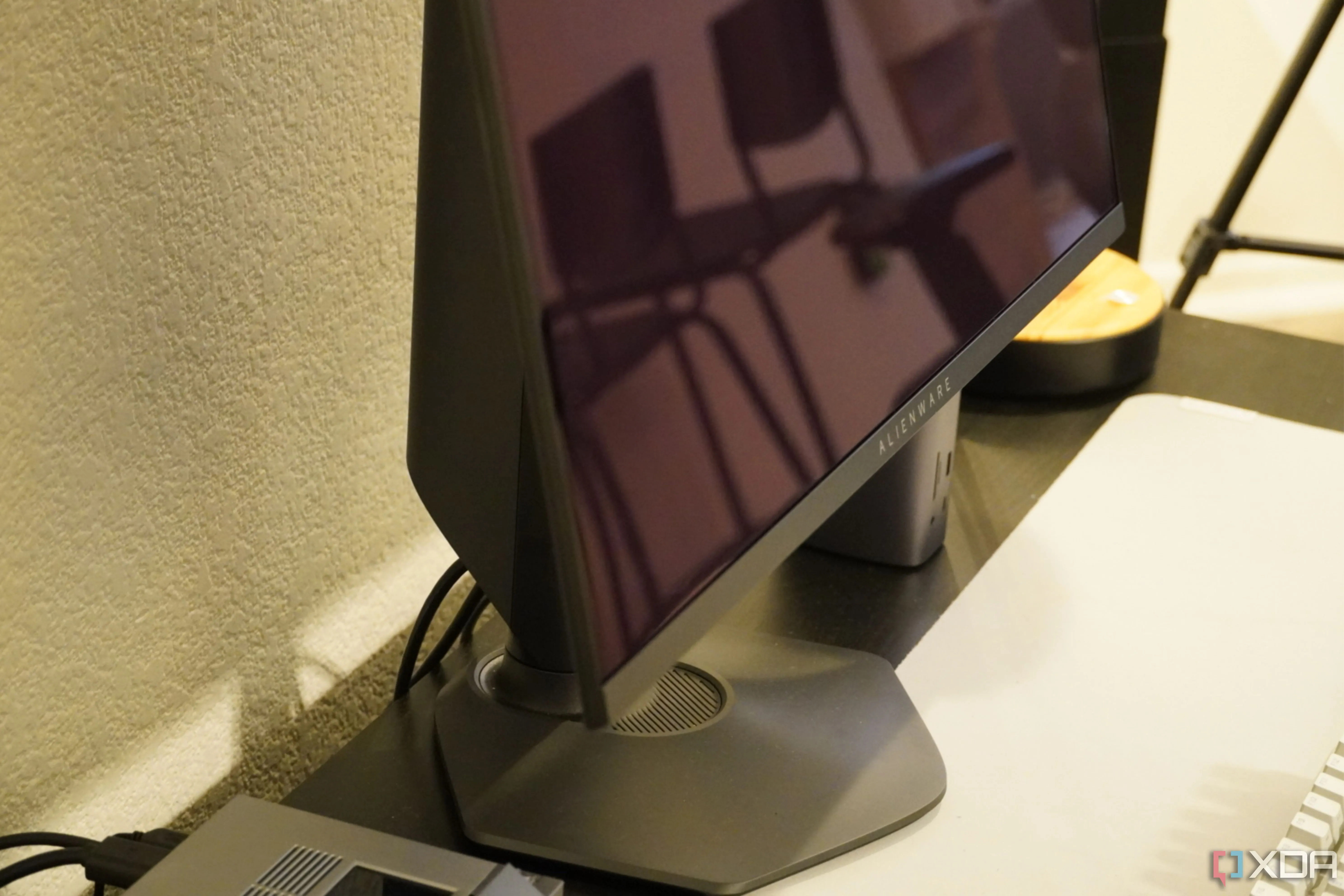 Góc dưới của màn hình chơi game Alienware QD-OLED 27, thể hiện bề mặt màn hình bóng và tiềm năng phản chiếu.