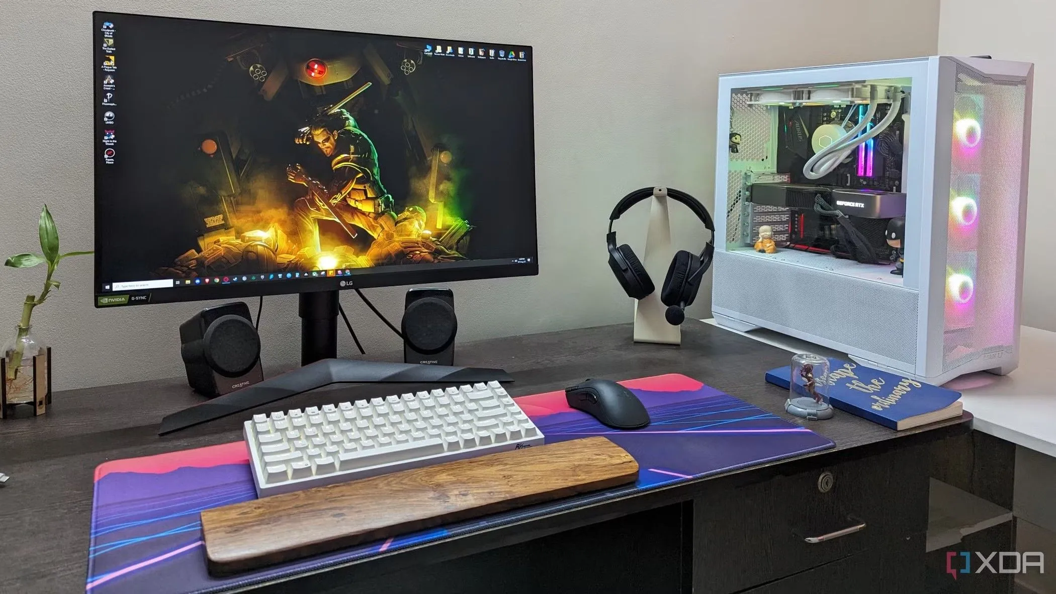 Góc làm việc với màn hình máy tính, bàn phím cơ và chuột gaming, thể hiện sự thoải mái khi sử dụng màn hình Mini-LED để làm việc và giải trí