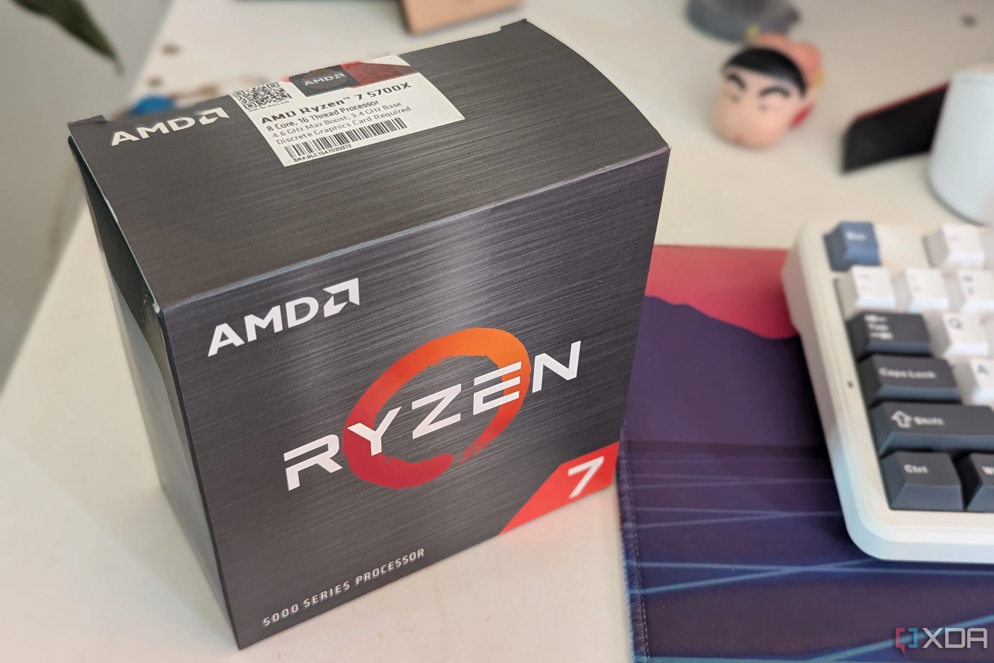 Hộp CPU AMD Ryzen 7 5700X đặt trên bàn làm việc cạnh bàn phím.