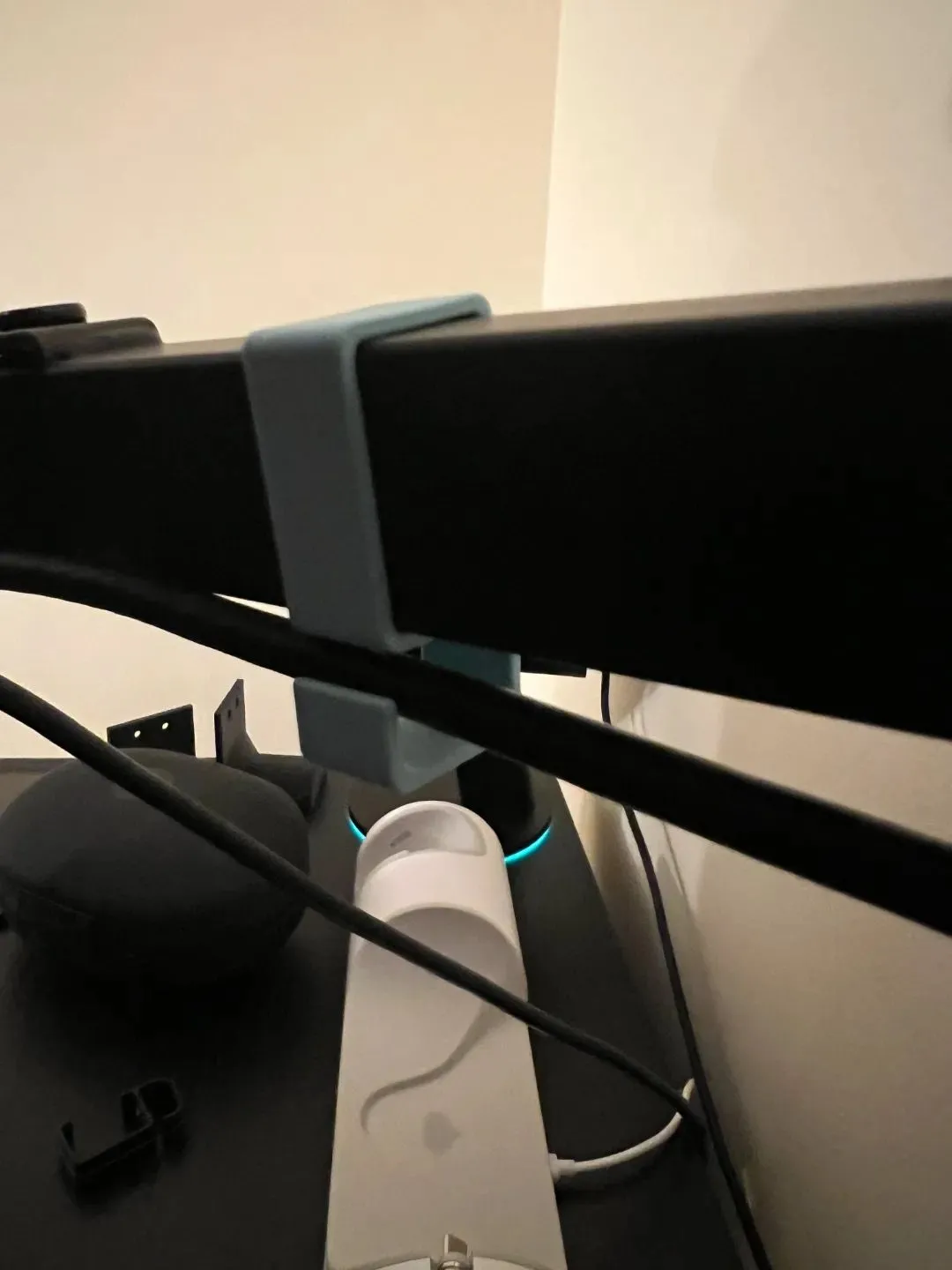 Kẹp cáp in 3D màu trắng của Tyago gắn phía sau màn hình, giúp định tuyến gọn gàng dây HDMI, DisplayPort và cáp nguồn