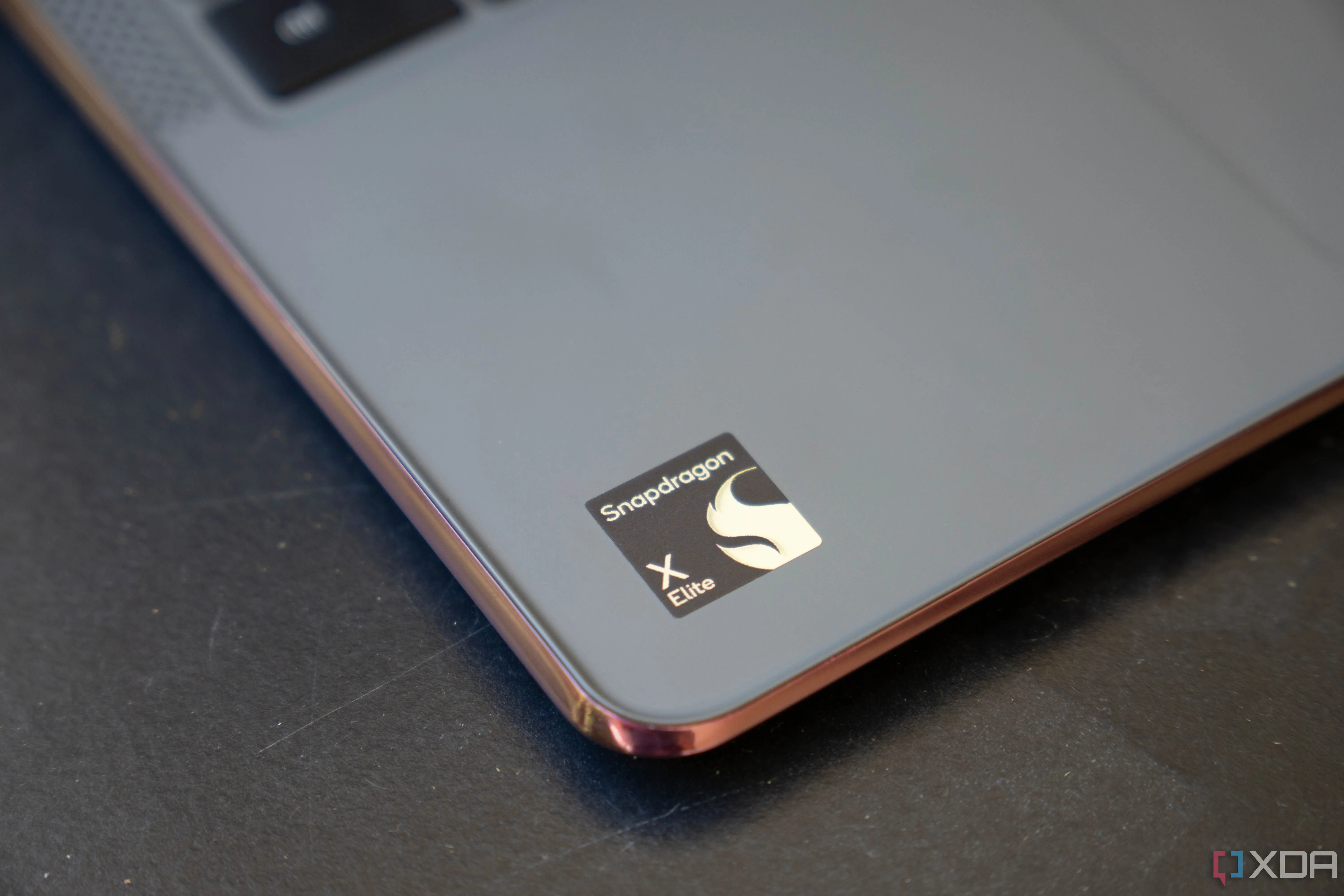 Logo Snapdragon X Elite trên phần kê tay của máy tính xách tay, thể hiện sức mạnh chip Arm cho Windows.