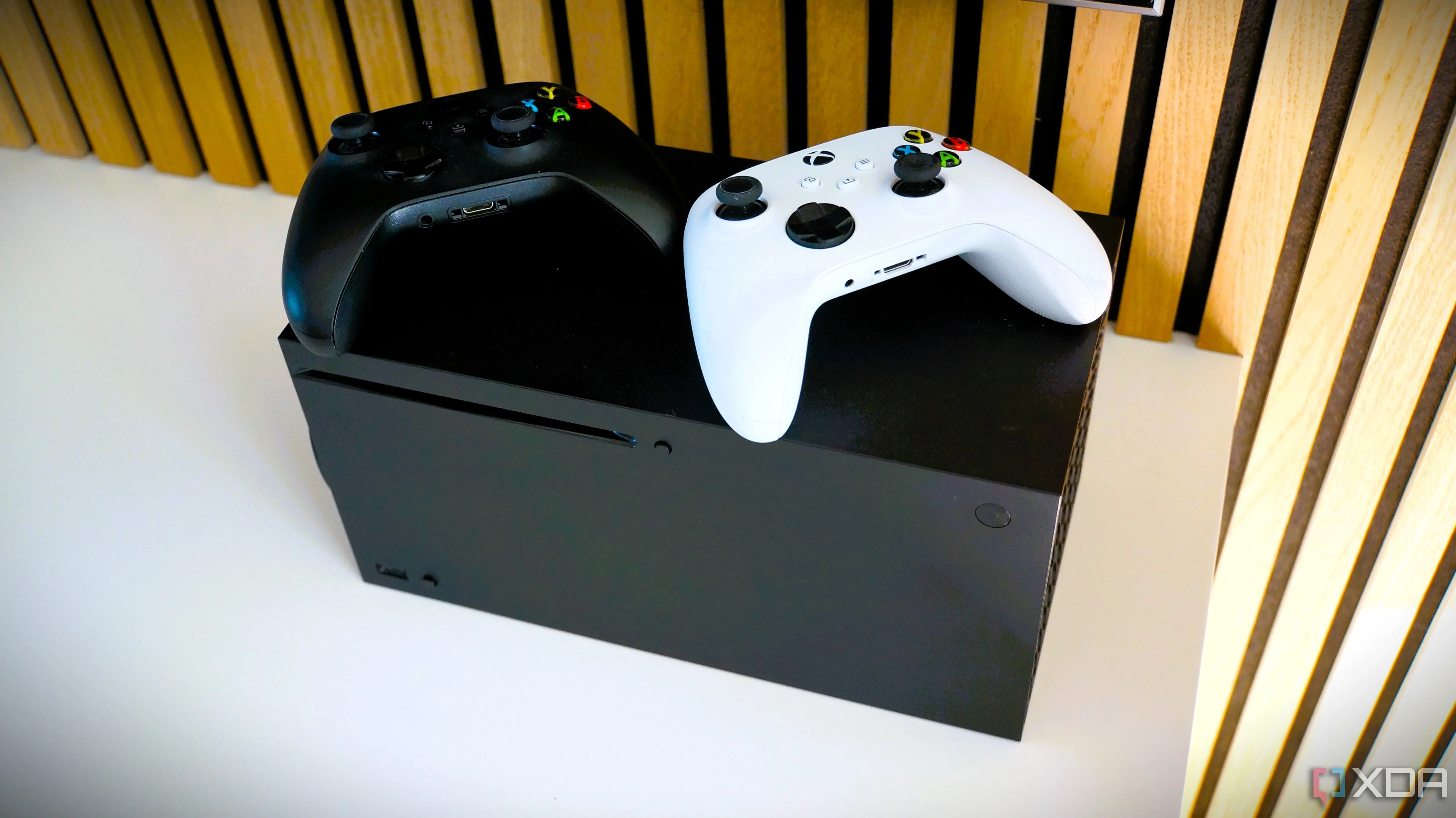 Máy chơi game Xbox Series X cùng bộ tay cầm điều khiển đen và trắng, đại diện cho hệ sinh thái Xbox Game Pass