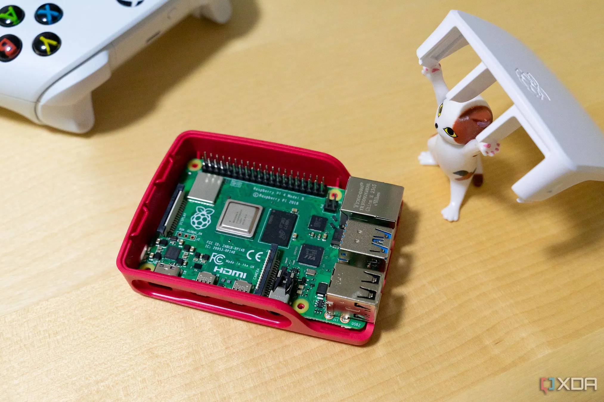 Mô hình mèo đồ chơi đang nhấc vỏ hộp để lộ bo mạch Raspberry Pi bên trong