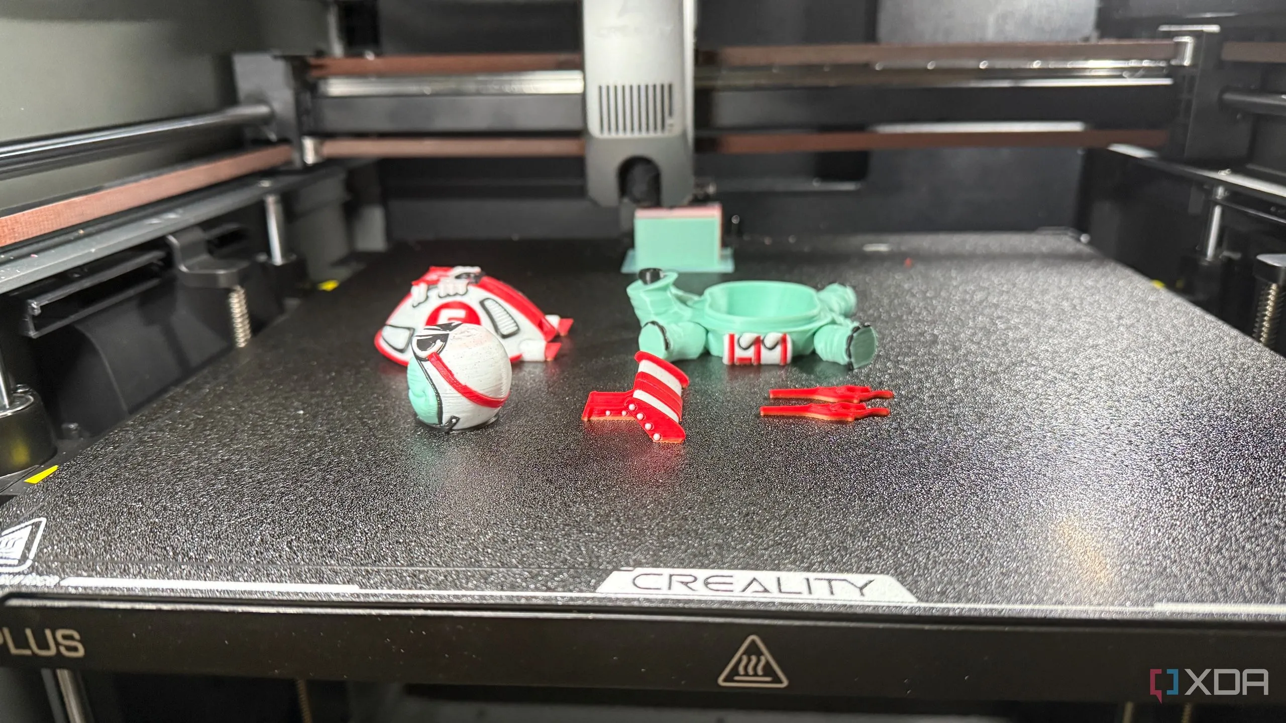Một mô hình 3D đang được in dở, minh họa quá trình tạo ra các chi tiết nhỏ như mắt kính và máy bắn tơ Spider-Man.