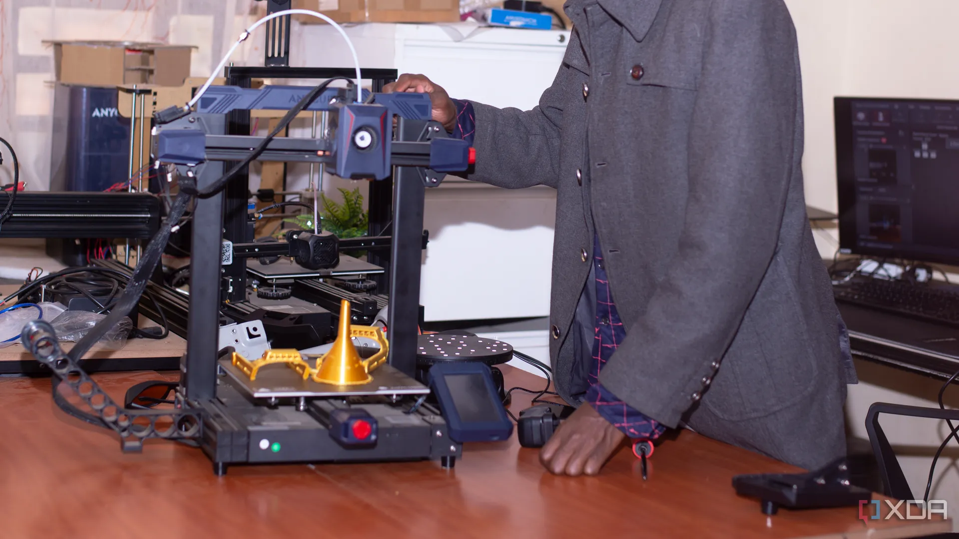 Một người đàn ông đang thực hiện công việc in 3D với máy Anycubic, tượng trưng cho việc in ấn hiệu quả thay vì sửa chữa.