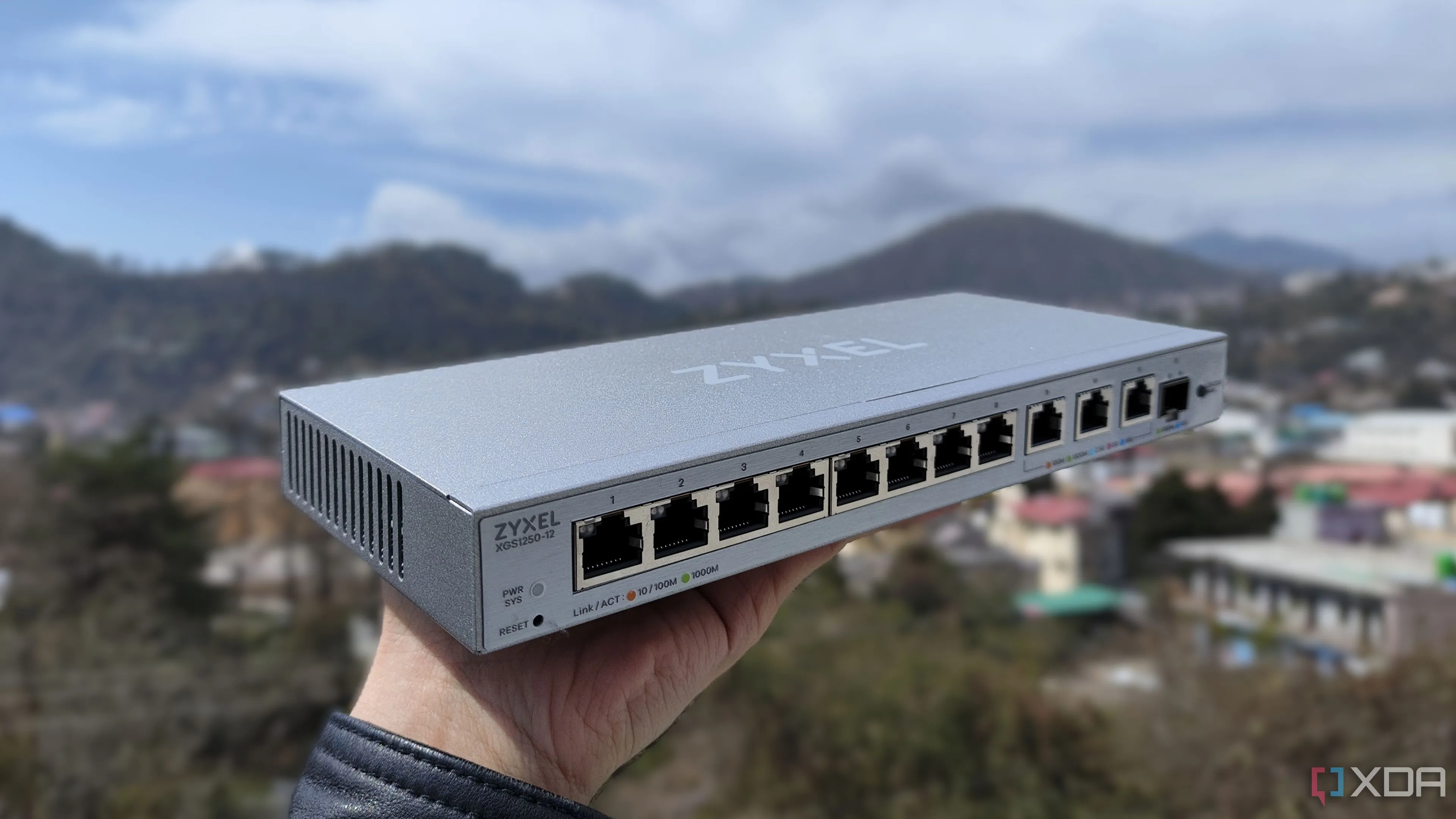 Một người đang cầm bộ chuyển mạch mạng (switch) Zyxel 2.5GbE, biểu trưng cho sự nâng cấp dễ dàng và hiệu quả của hạ tầng mạng gia đình.