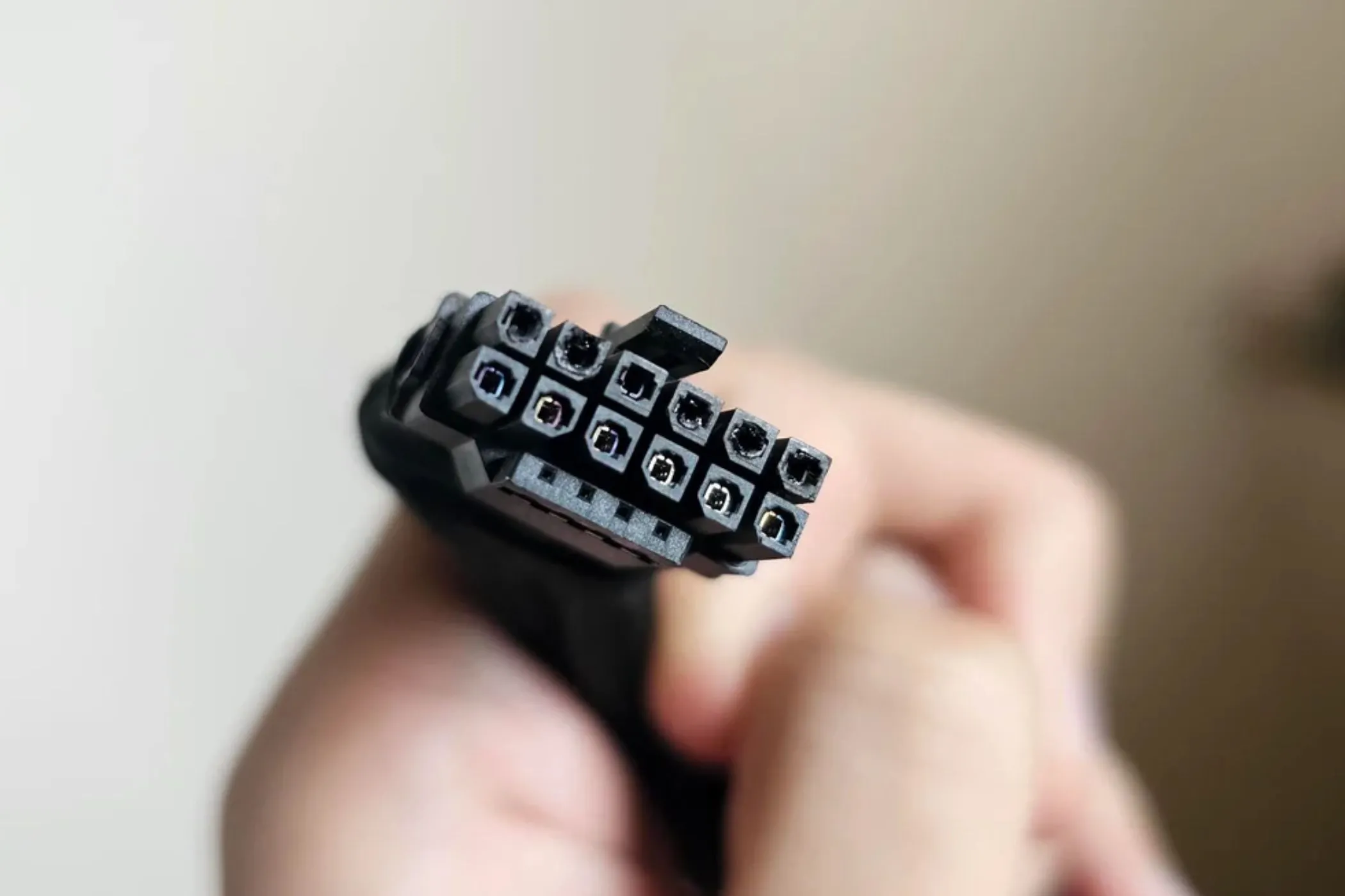 Một người đang cầm cáp nguồn 12VHPWR bị cháy, minh chứng cho lỗi nóng chảy