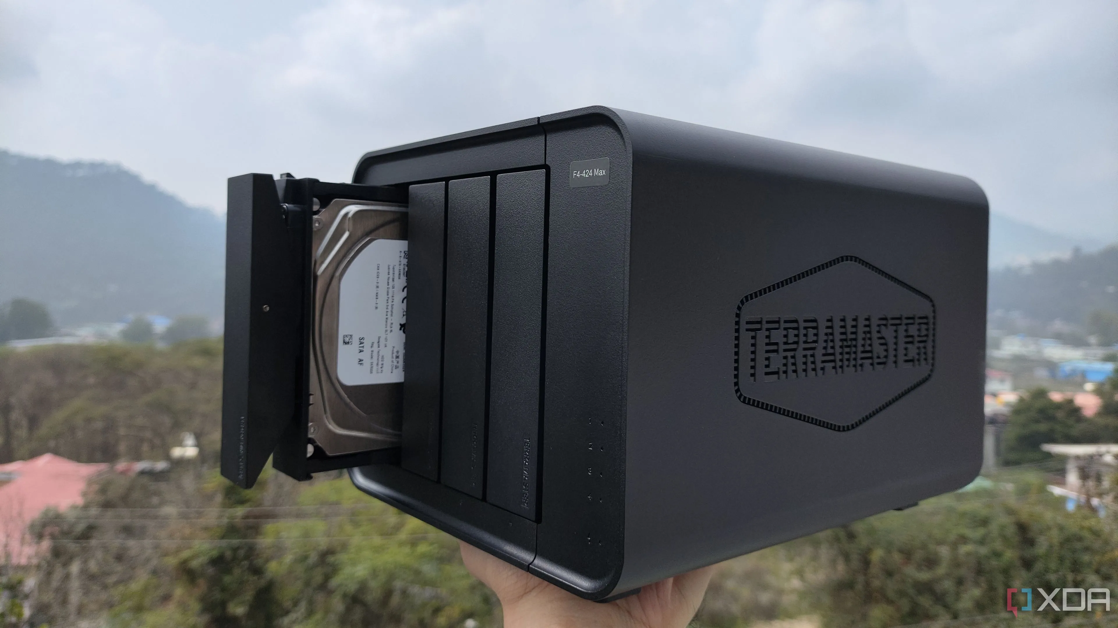 Một người đang cầm thiết bị NAS TerraMaster F4-424 Max, tượng trưng cho giải pháp lưu trữ mở rộng.