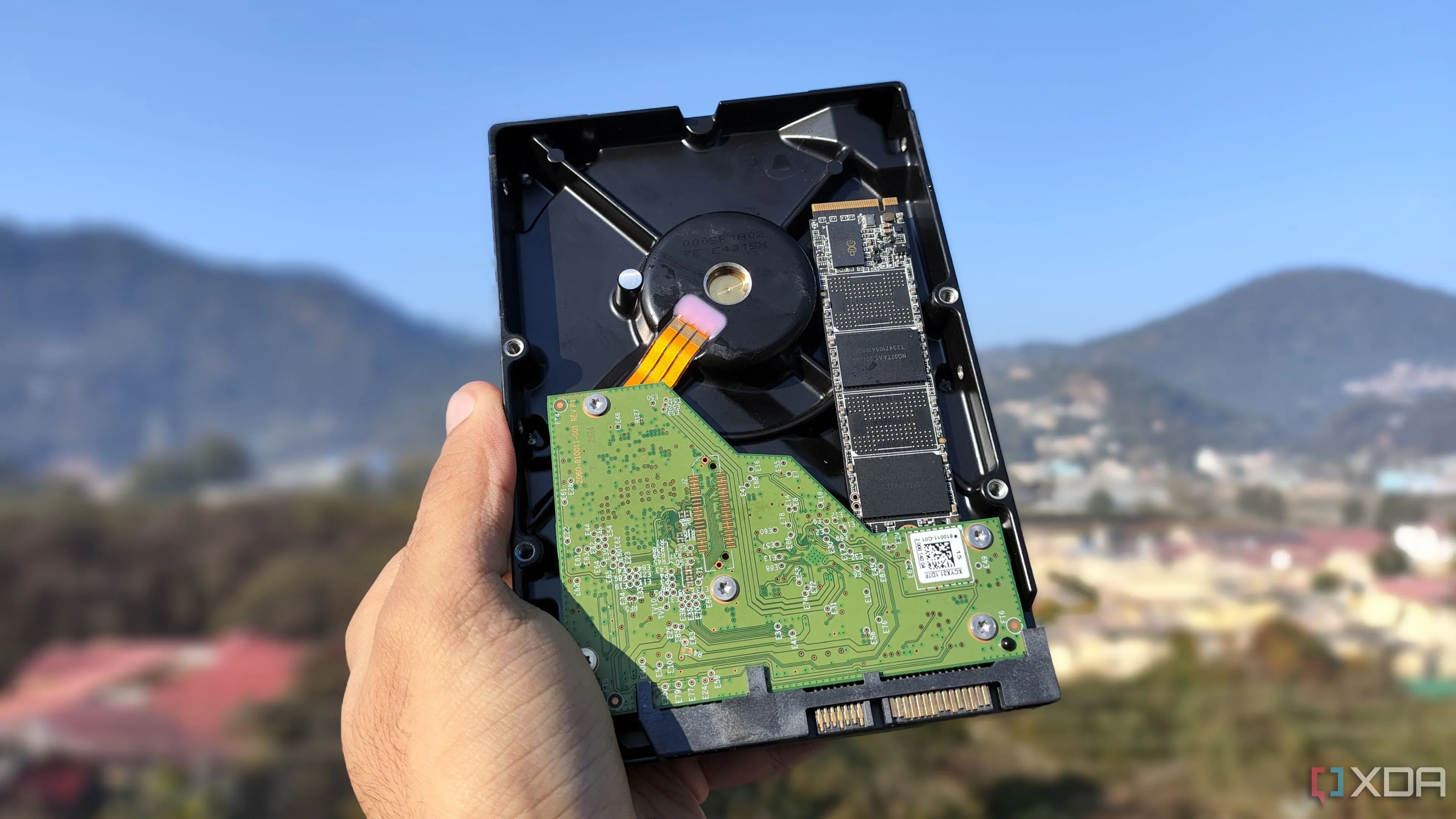 Một người đang cầm trên tay ổ cứng HDD và SSD, thể hiện sự khác biệt về kích thước và công nghệ lưu trữ giữa hai loại ổ đĩa, phù hợp cho việc lưu trữ dữ liệu dài hạn trên các thiết bị NAS