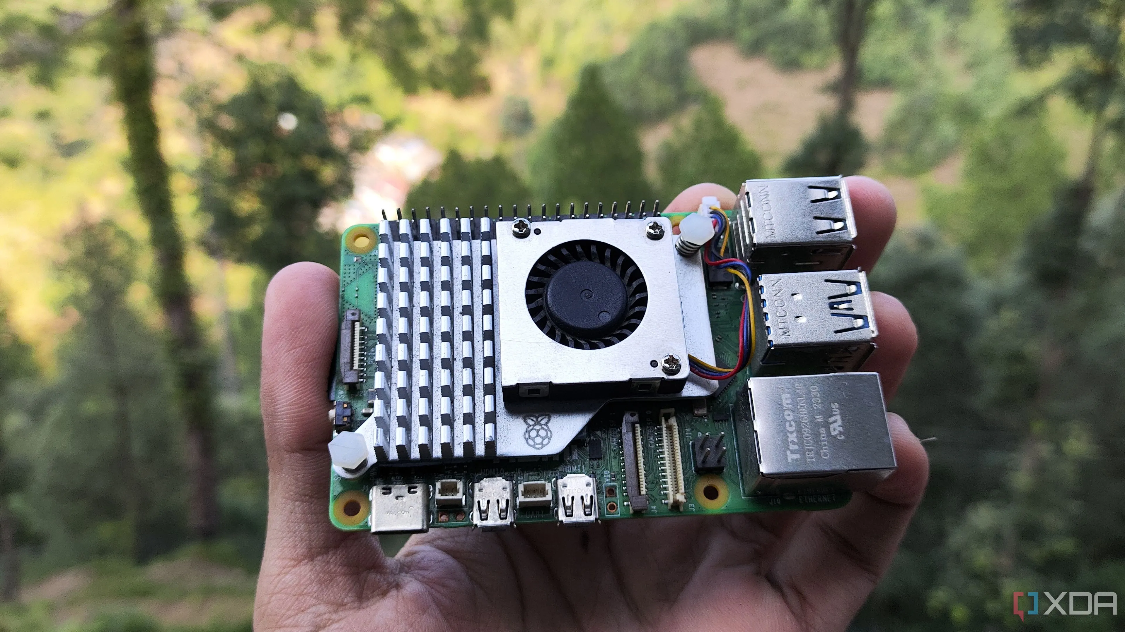 Người đang cầm bo mạch máy tính mini Raspberry Pi 5