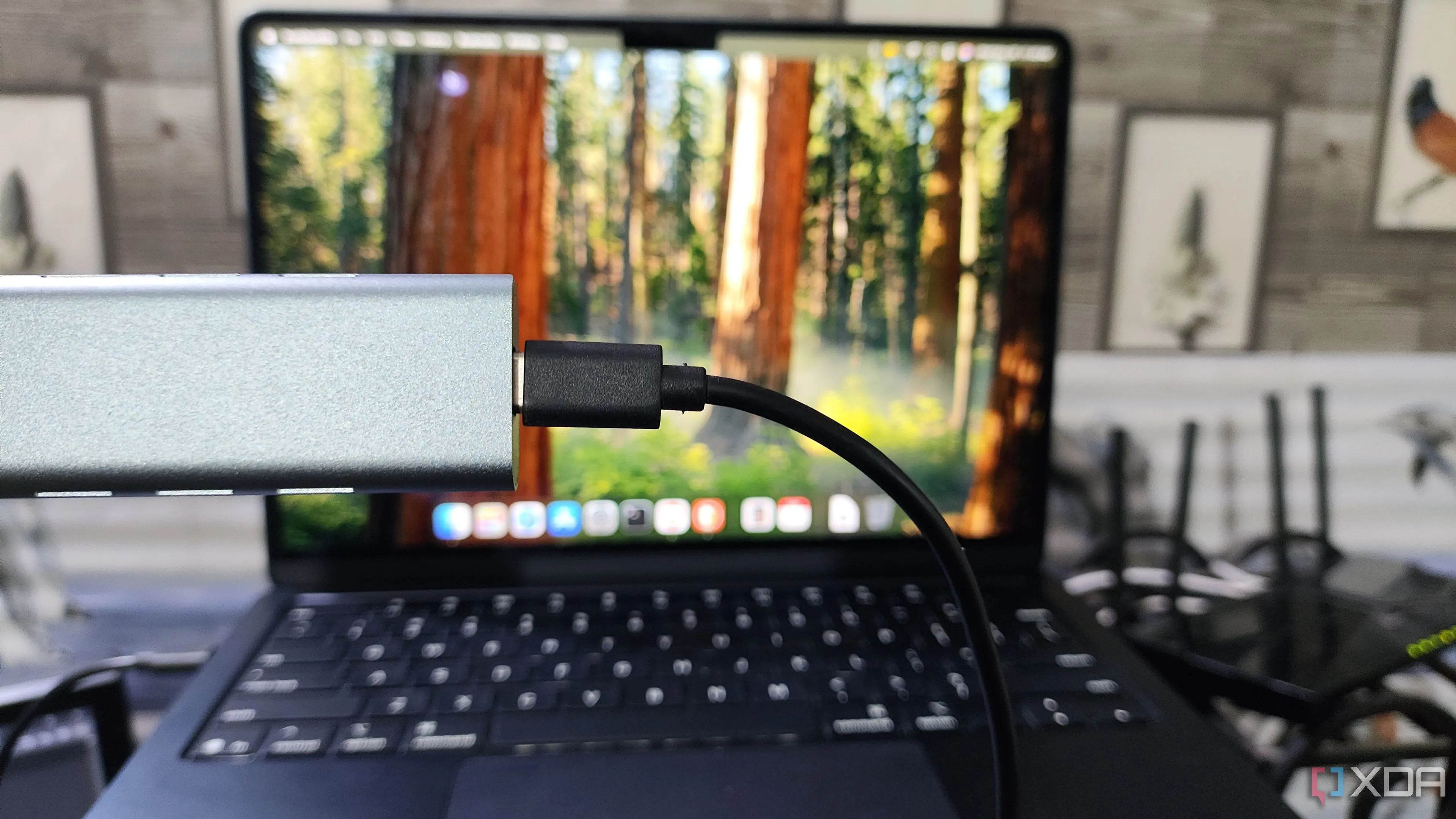 Người dùng cầm vỏ box NVMe SSD trước MacBook Air M4, minh họa giải pháp lưu trữ ngoài