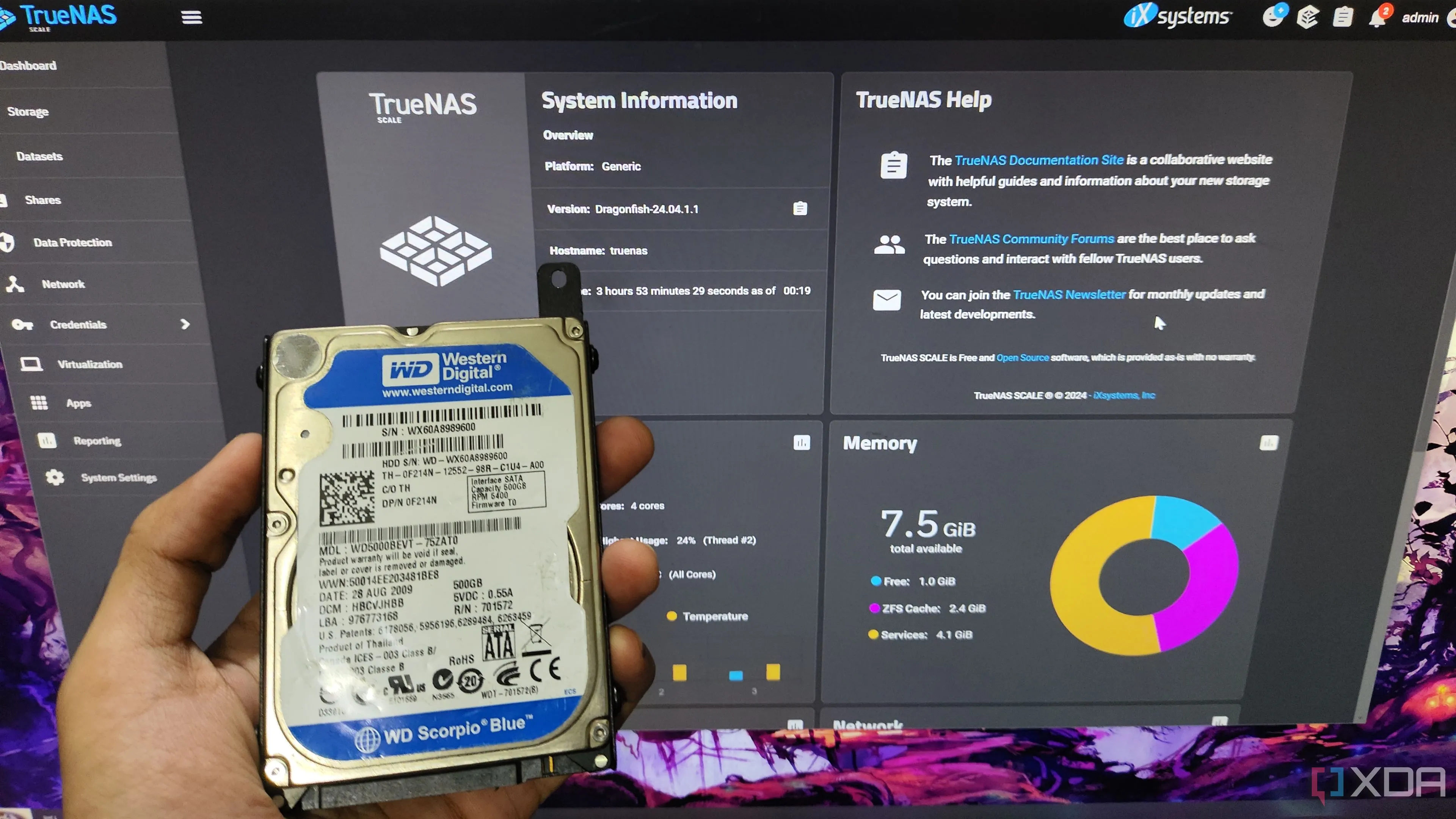 Người dùng đang cầm ổ cứng HDD trước giao diện TrueNAS Scale
