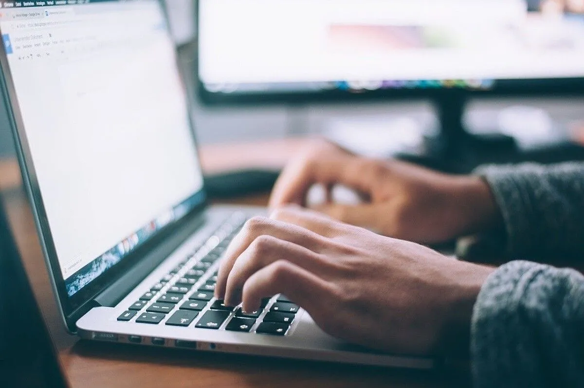 Người dùng đang gõ trên máy tính Mac, tượng trưng cho sự linh hoạt và tính cộng đồng của PowerShell mã nguồn mở