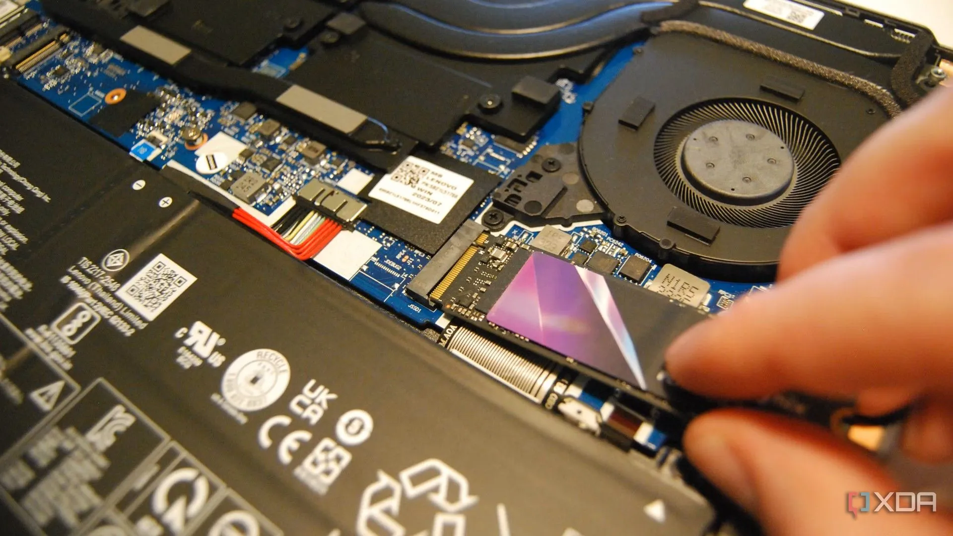 Người dùng đang lắp đặt ổ cứng SSD M.2 NVMe vào khe cắm trên bo mạch chủ máy tính