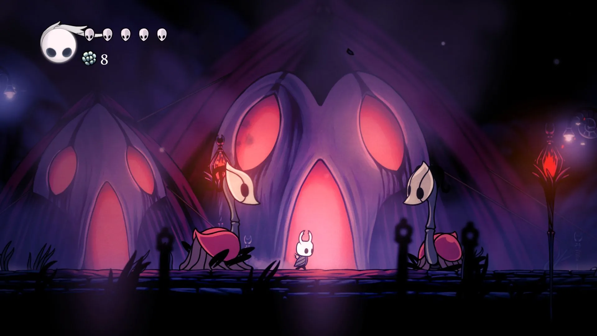 Nhân vật chính của Hollow Knight đứng giữa hai sinh vật trong một khung cảnh game đậm chất nghệ thuật