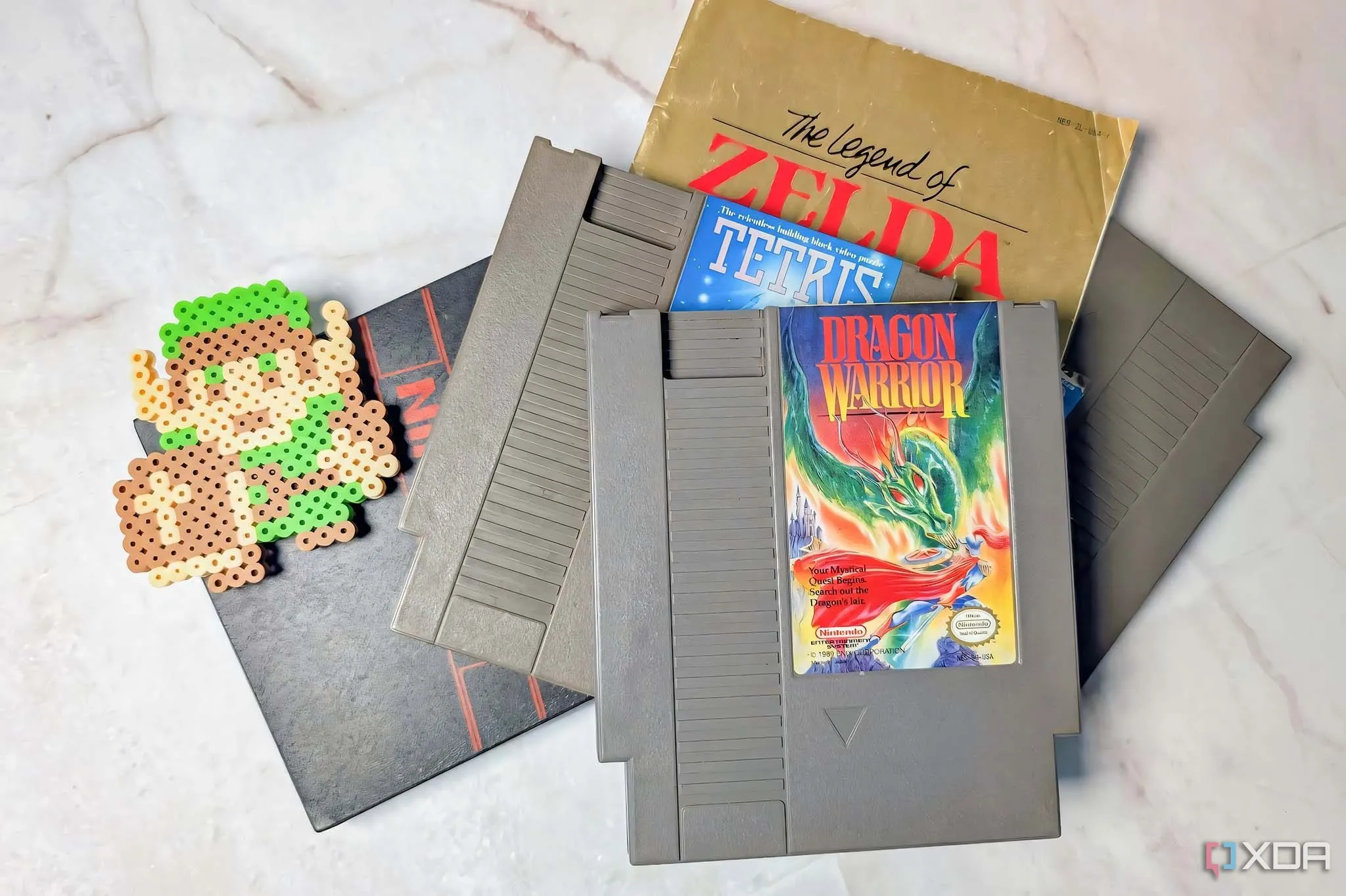 Những băng game NES cổ điển xếp chồng lên nhau với biểu tượng Legend of Zelda, gợi nhớ về thời kỳ game "khó nhằn" của Nintendo