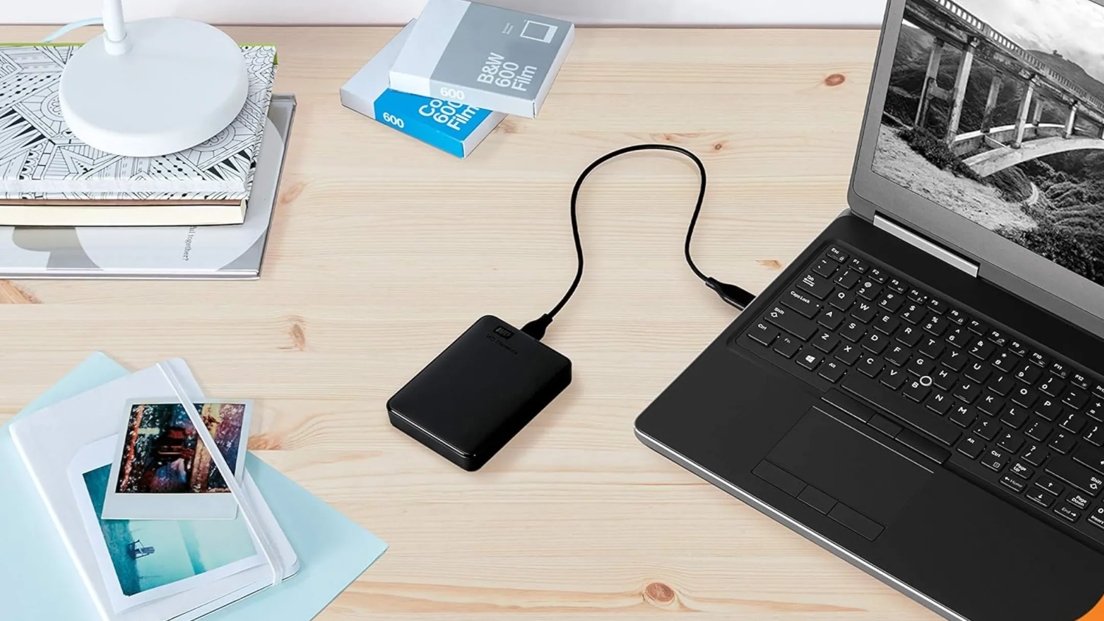 Ổ cứng di động WD Elements 5TB kết nối với laptop trên bàn làm việc, tượng trưng cho giải pháp sao lưu cục bộ