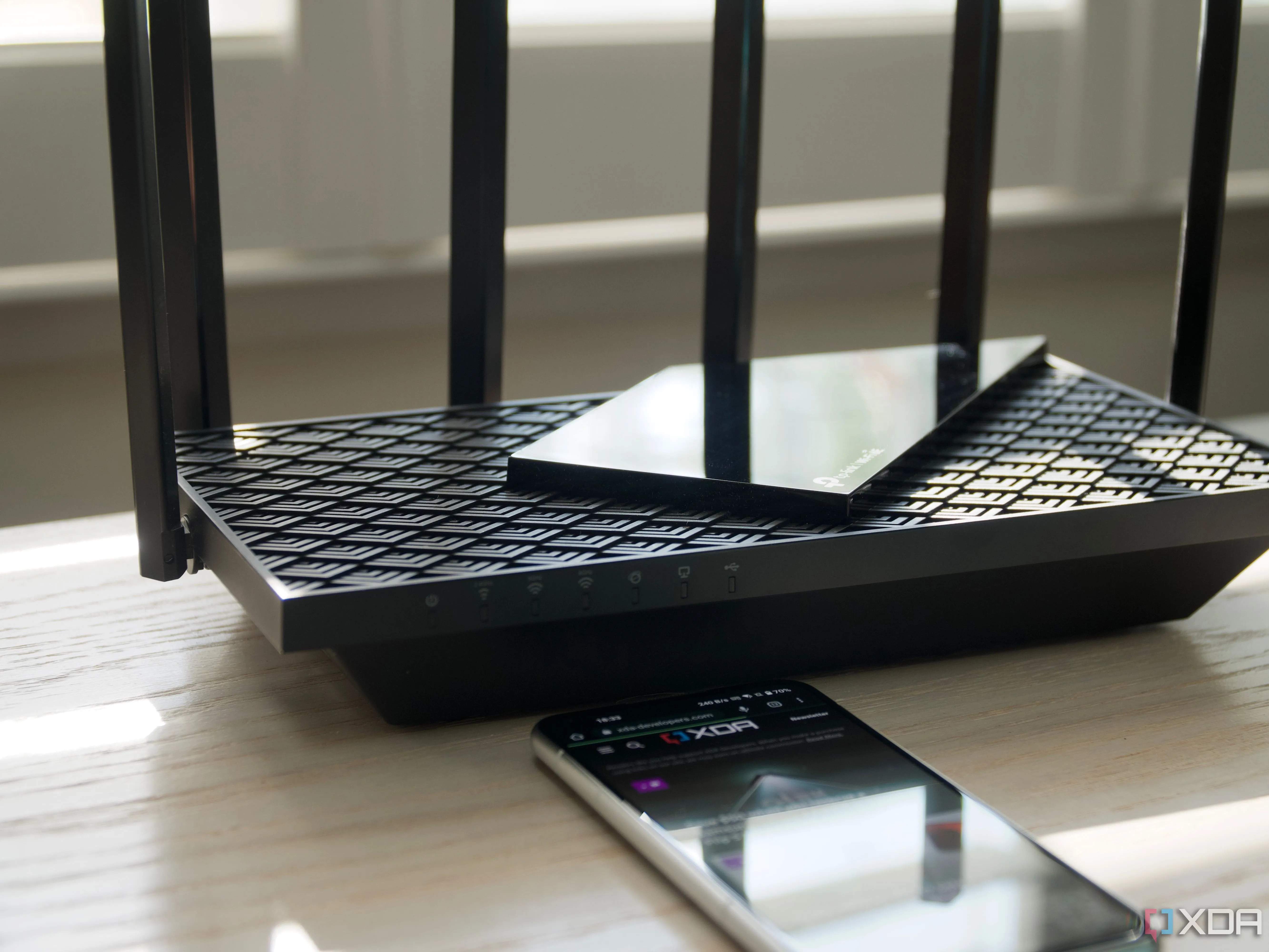 Router Wi-Fi 6E TP-Link Archer AXE75 ba băng tần đặt trên bàn, biểu tượng cho trung tâm mạng gia đình hiện đại