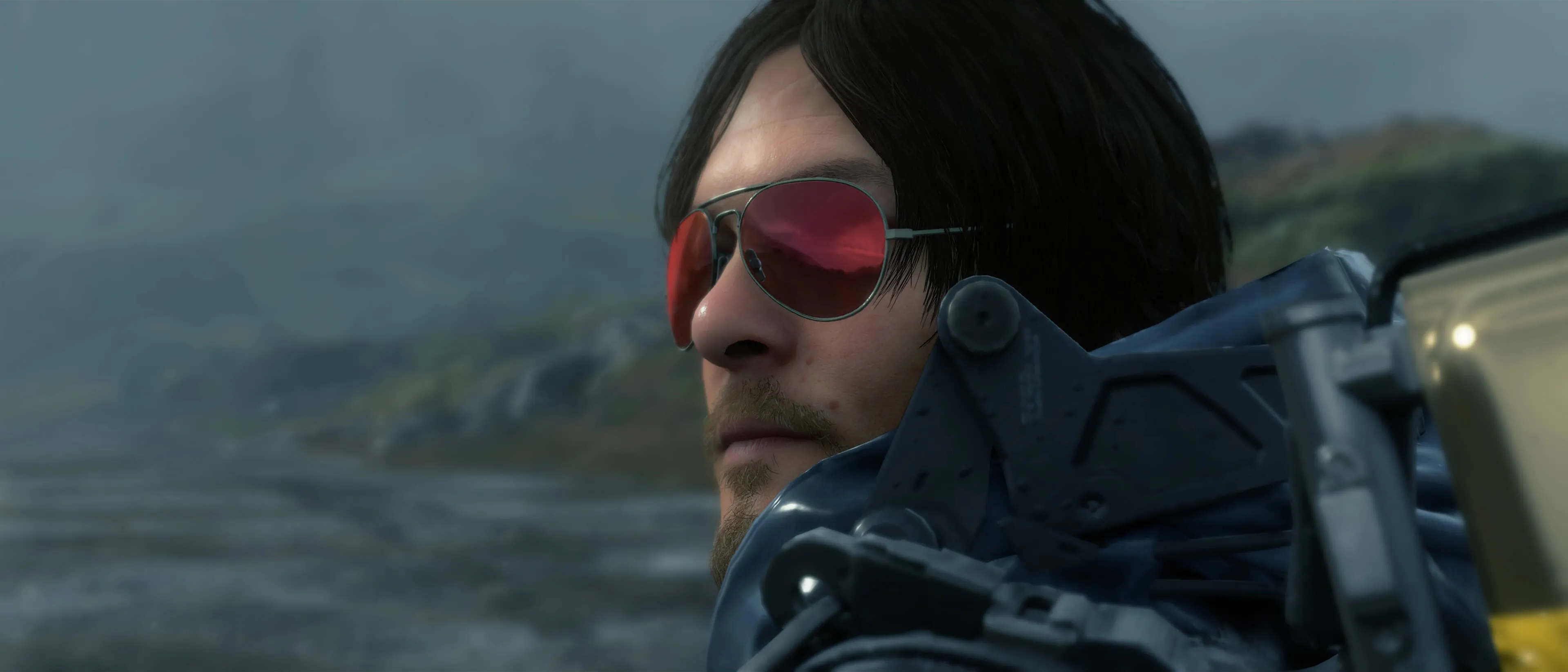 Sam Porter Bridges, nhân vật chính của Death Stranding, đeo kính râm trong một phân cảnh của trò chơi.