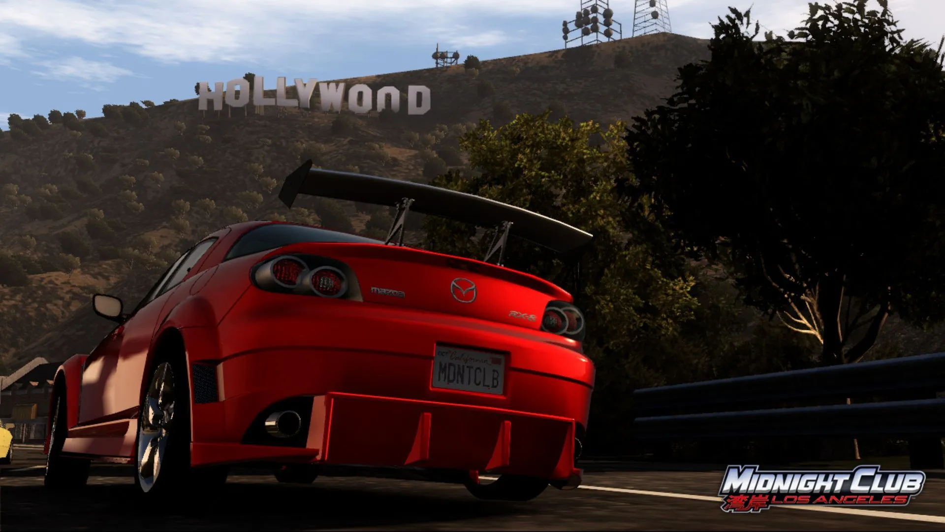 Screenshot từ Midnight Club: Los Angeles hiển thị chiếc Mazda màu cam trên đường với biển hiệu Hollywood ở hậu cảnh
