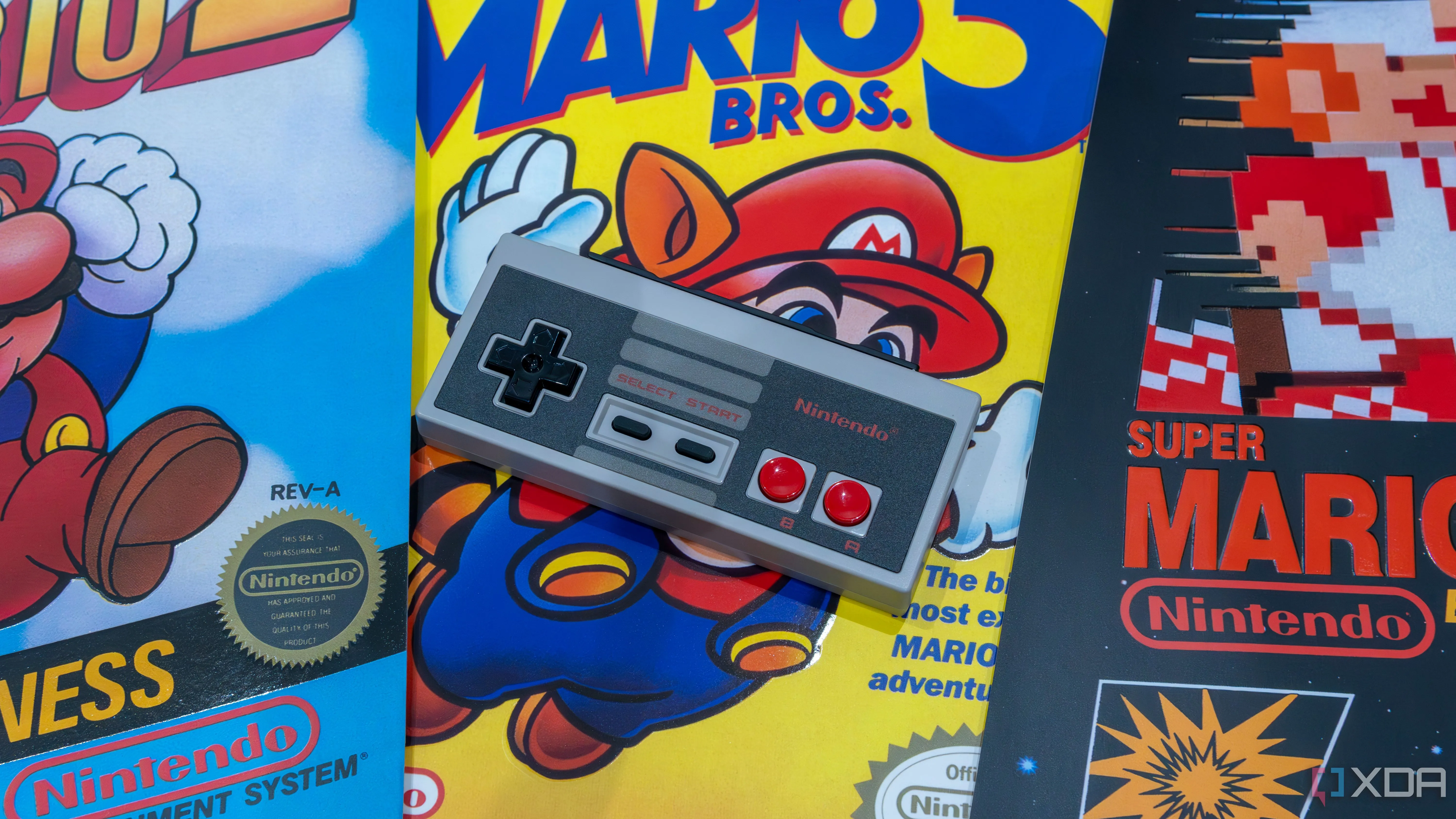 Tay cầm NES bản sao đặt trên hình ảnh các tựa game Mario kinh điển, gợi nhớ về kỷ niệm game Nintendo