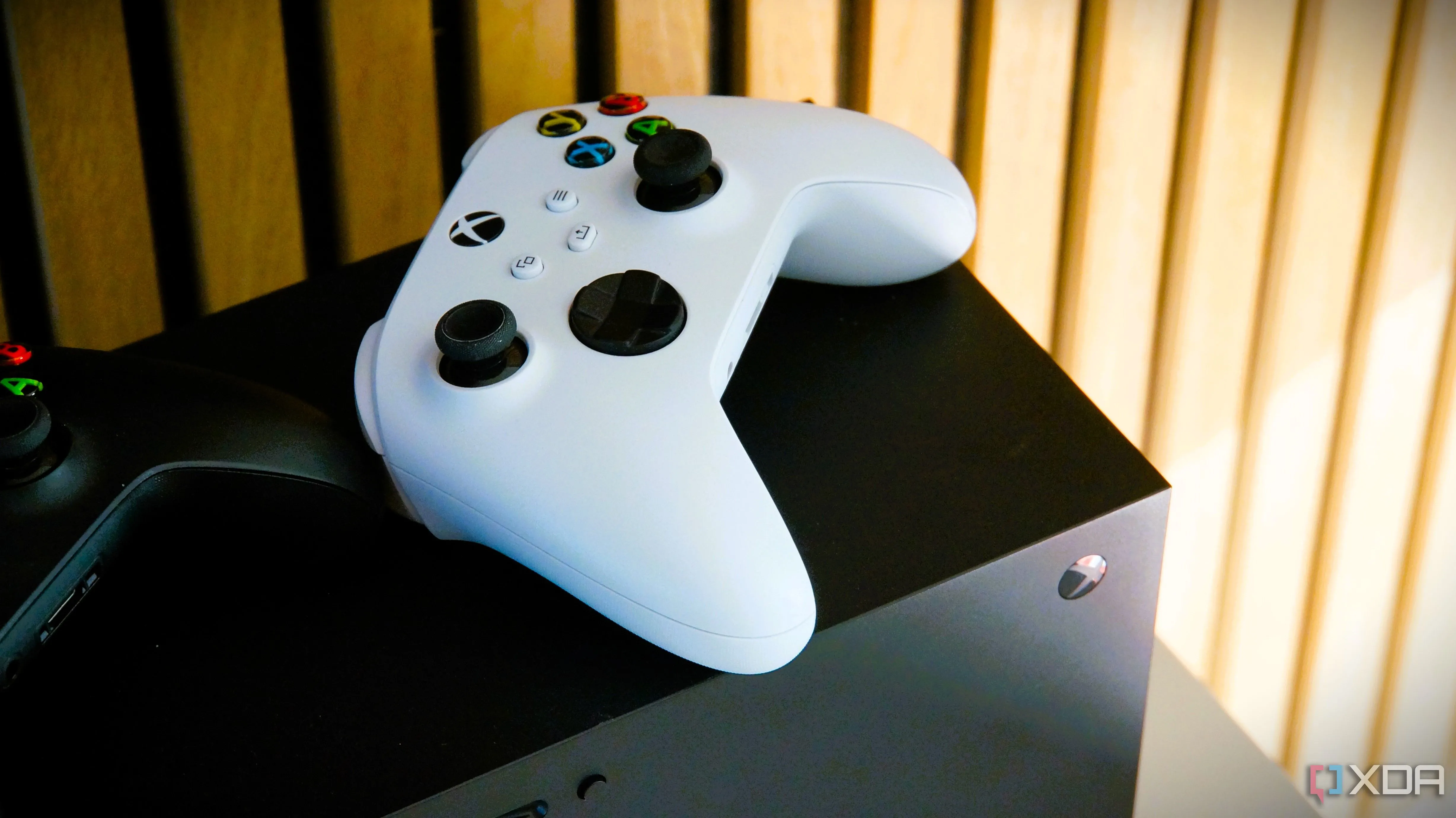 Tay cầm Xbox Series X màu trắng đặt trên thân máy console Xbox Series X