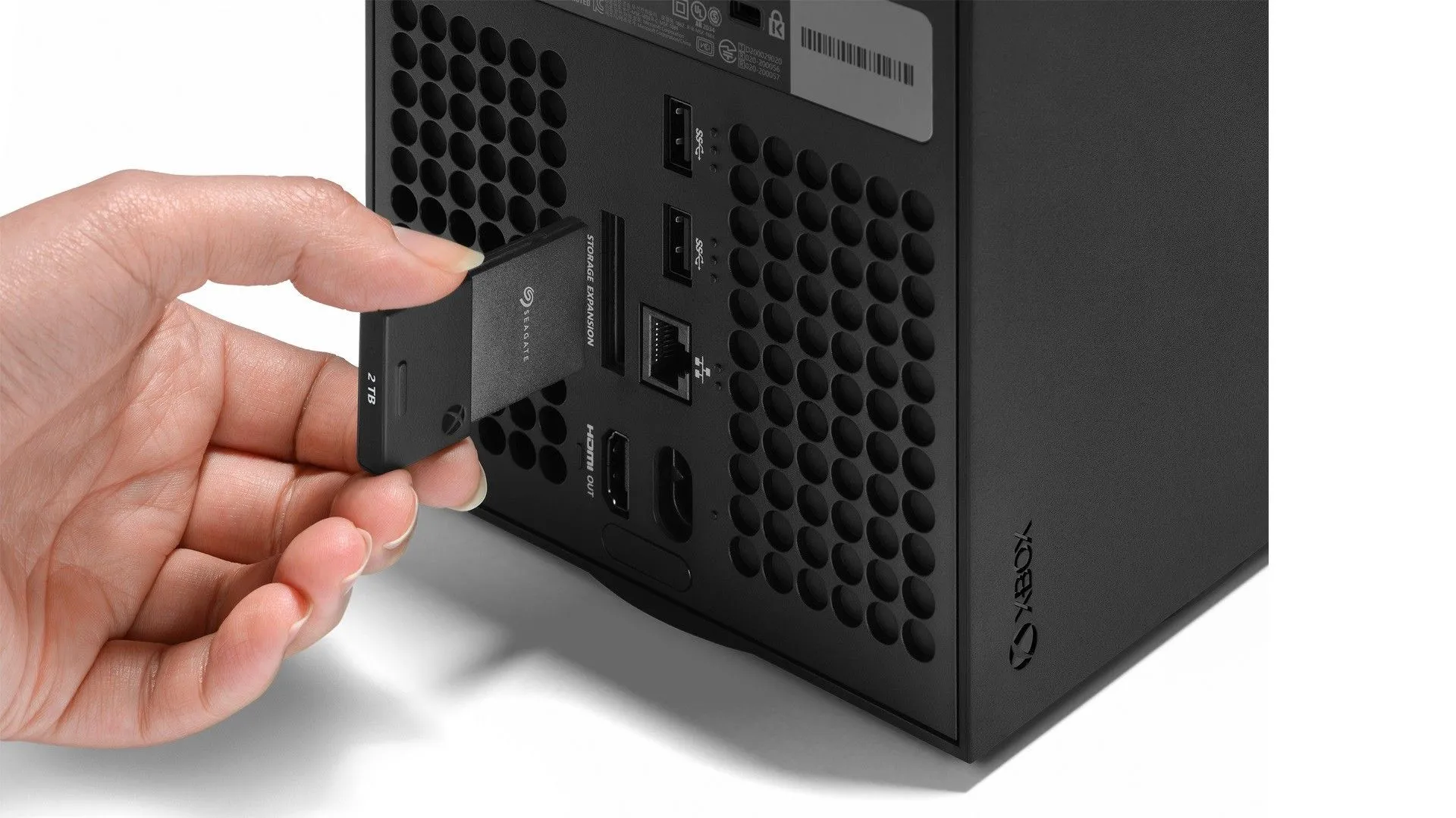 Thẻ mở rộng SSD độc quyền đang được cắm vào cổng phía sau của Xbox Series X, cho thấy cách lưu trữ hiện tại của Microsoft.