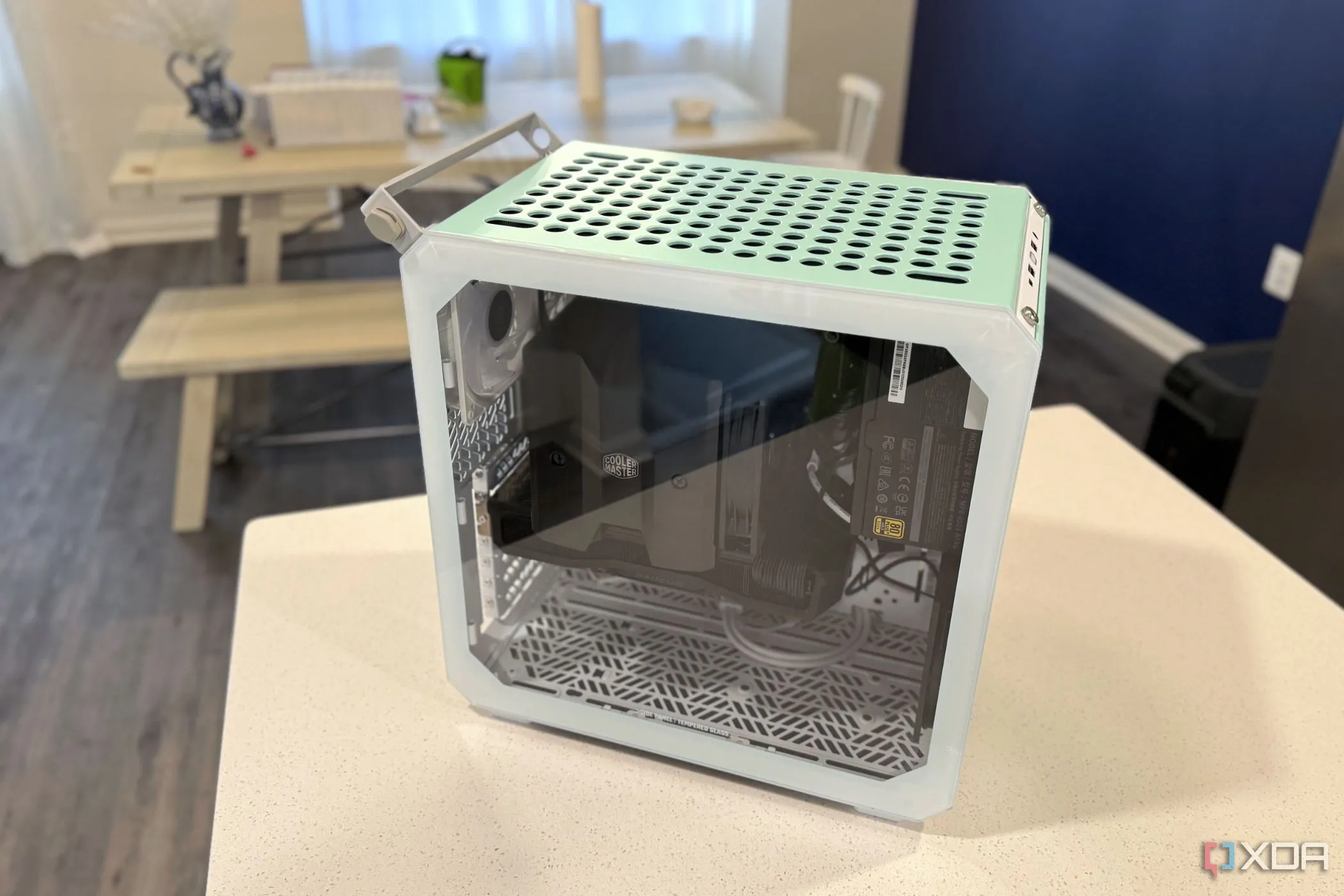 Vỏ case máy tính Small Form Factor Cooler Master Qube 500 đặt trên bàn bếp, nhấn mạnh kích thước nhỏ gọn nhưng tiềm ẩn thách thức về tản nhiệt.